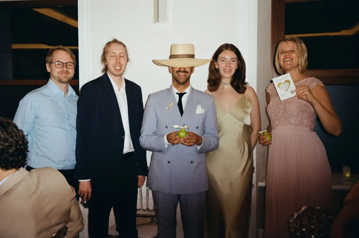 Guests laughing together at a wedding party, on 35mm film