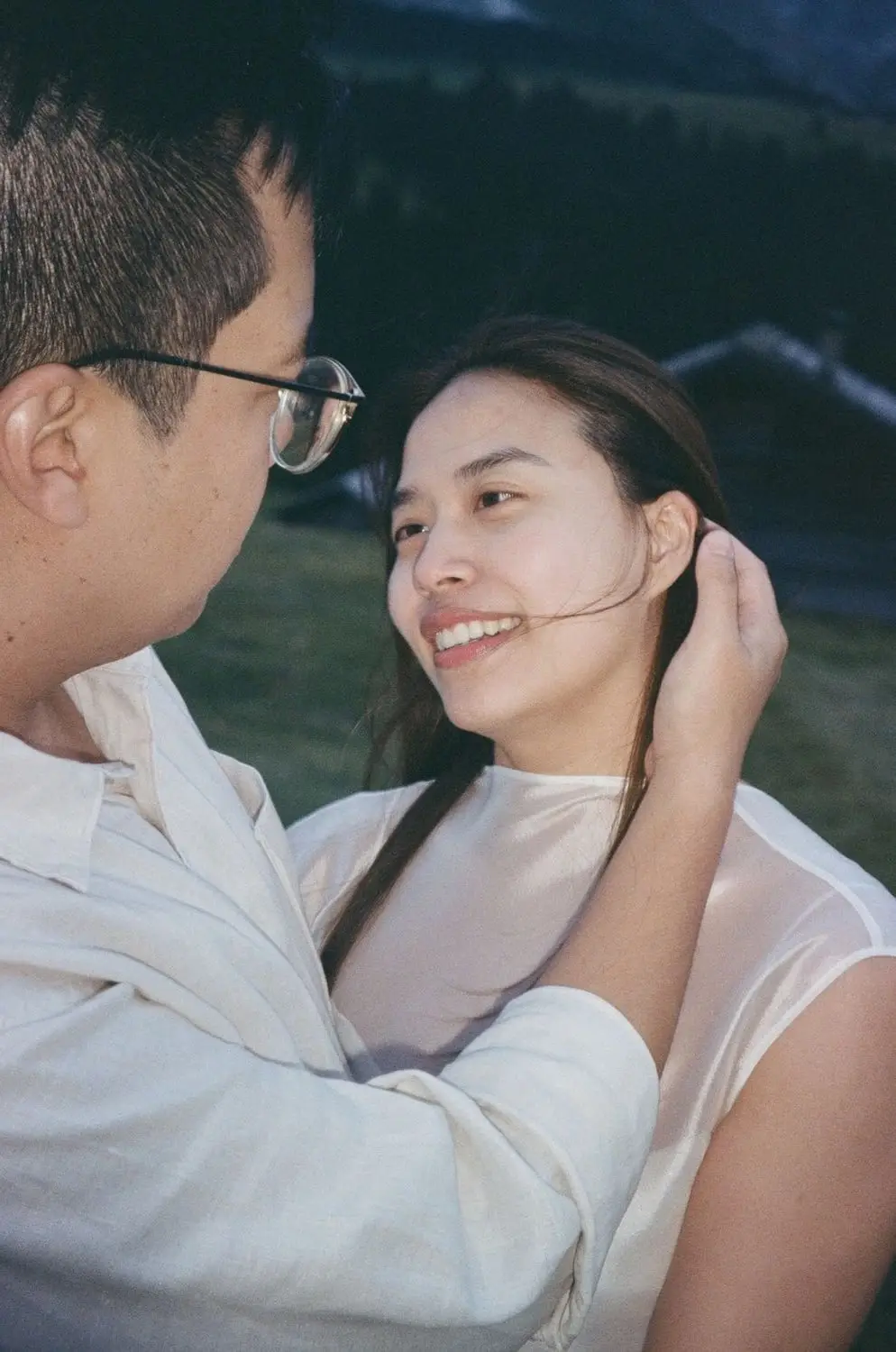 Couple lying close together, laughing, on 35mm film