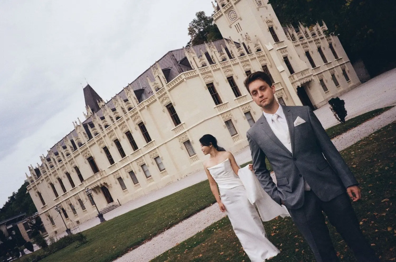 Bride and groom walking by Schloss Hernstein, on 35mm film
