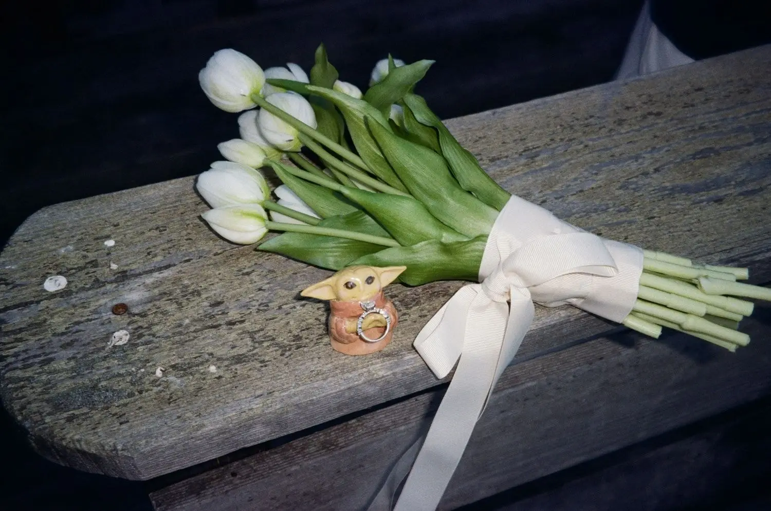White tulip bouquet on a wooden bench, on 35mm film