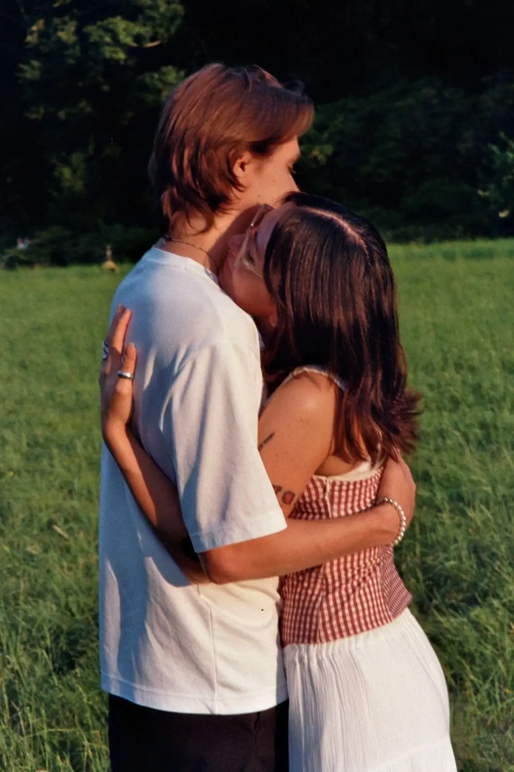 Couple embracing in a meadow, on 35mm film