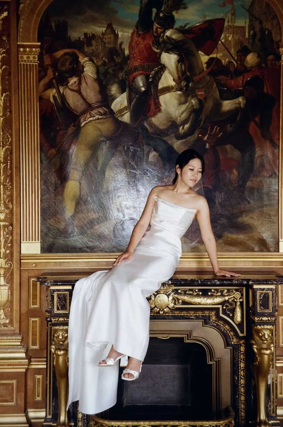 Bride lying in front of a gilded painting, on 35mm film