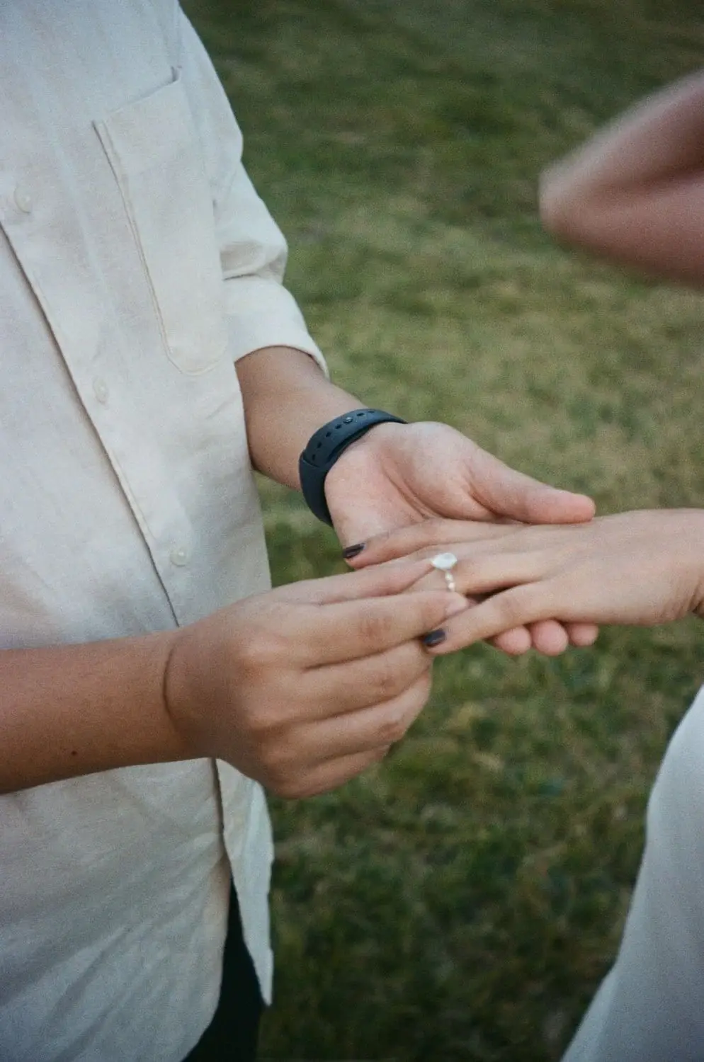 Close-up of hands with an engagement ring, on 35mm film