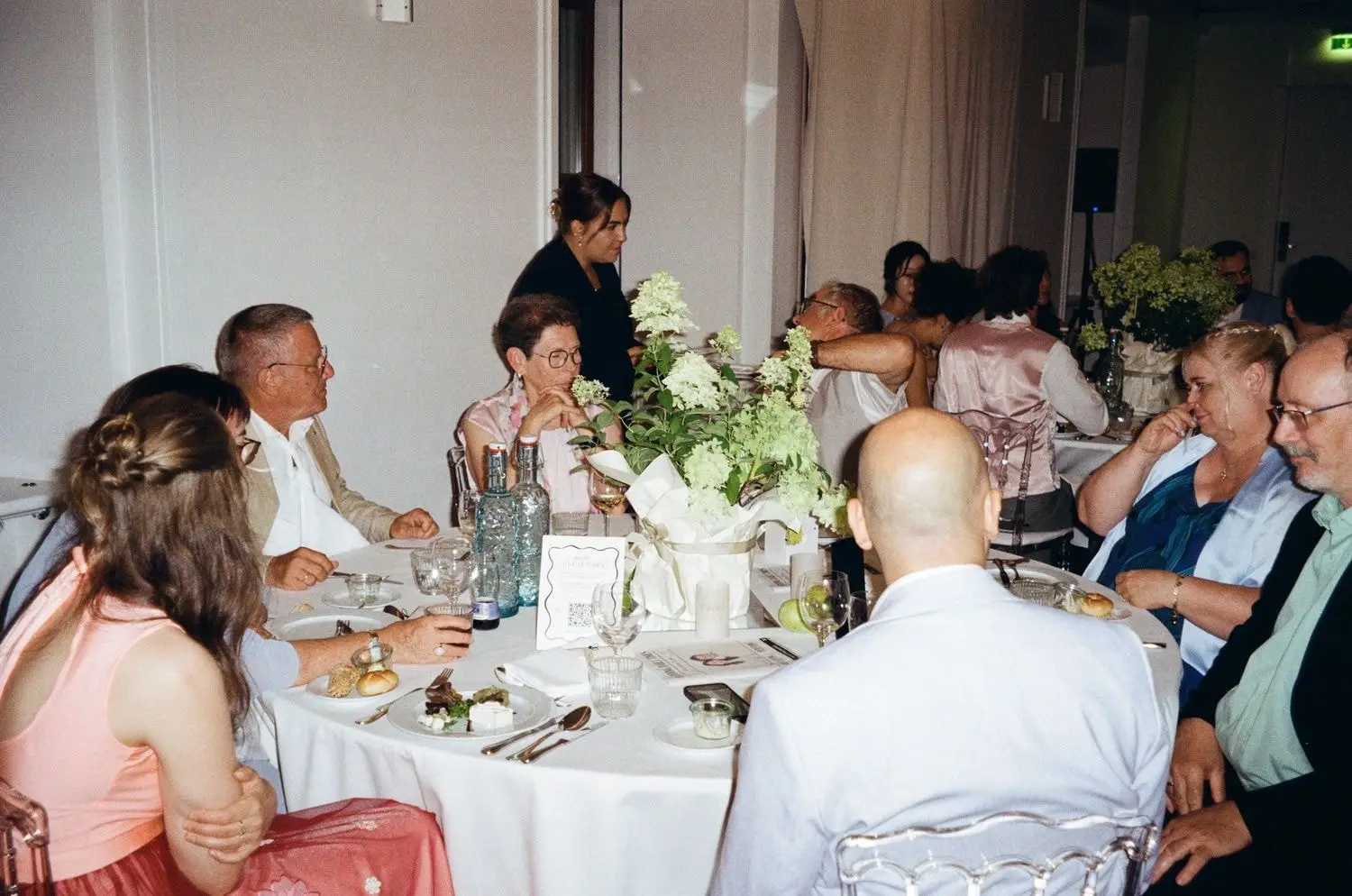 Guests talking at the wedding dinner, on 35mm film