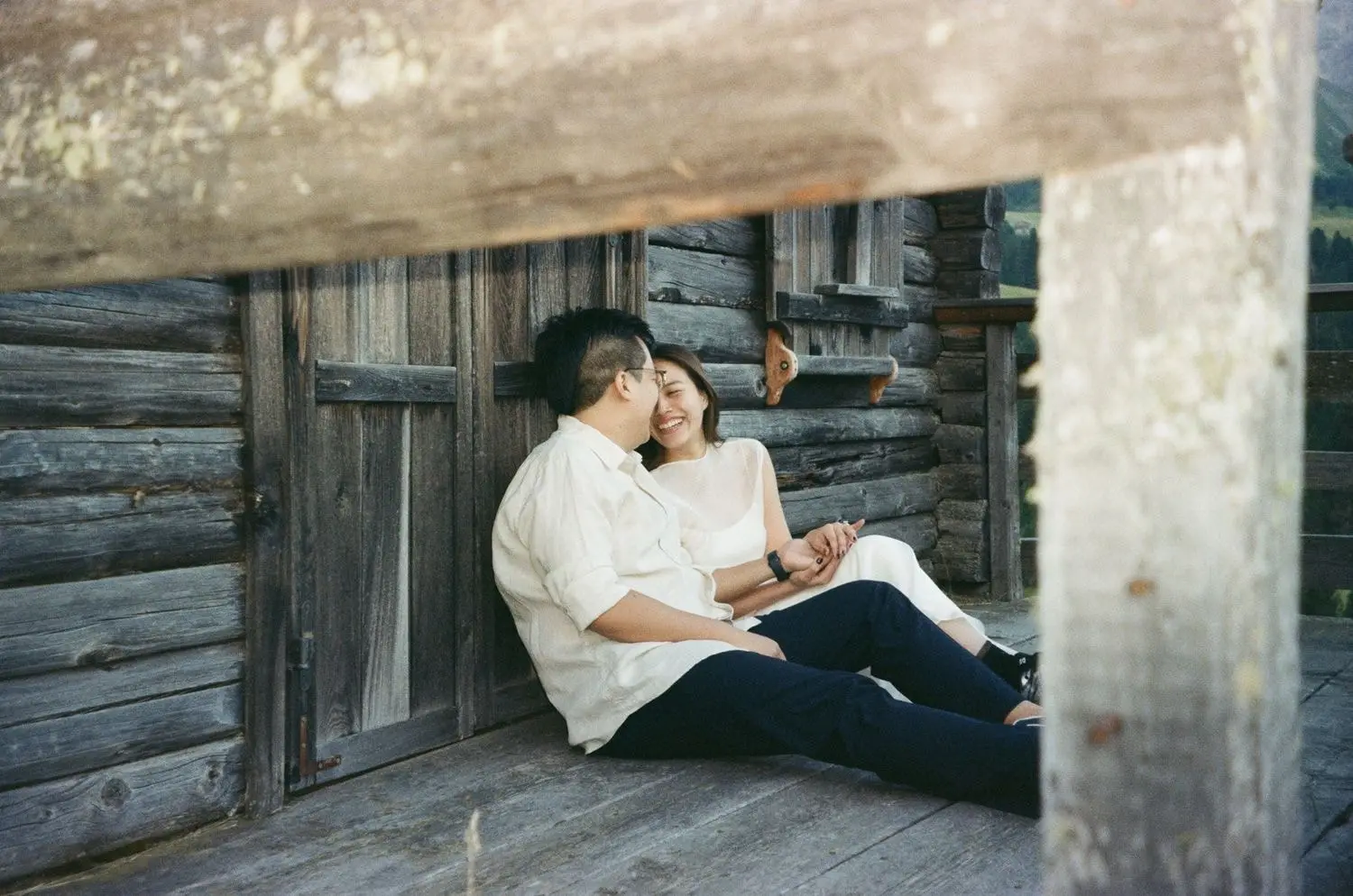 Couple on the porch of a wooden mountain hut, on 35mm film