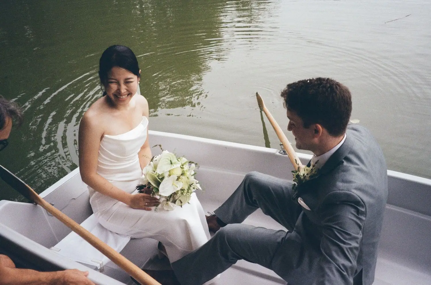 Couple laughing in a white rowing boat on the castle lake, on 35mm film