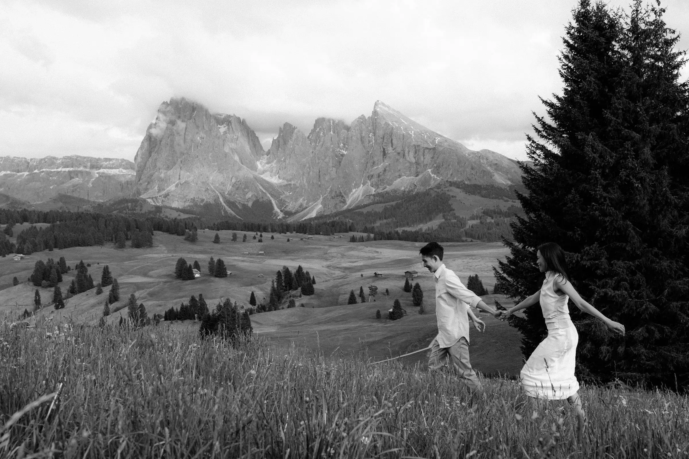Black and white photo of the couple dancing in the meadow below the Sassolungo