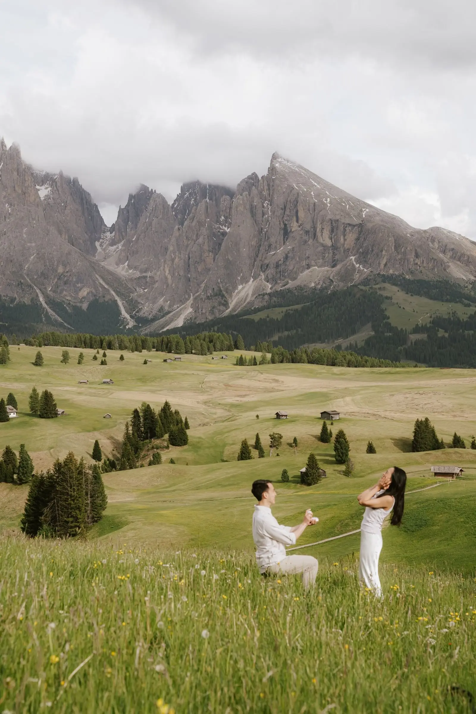 Man down on one knee in front of the Sassolungo on the Alpe di Siusi