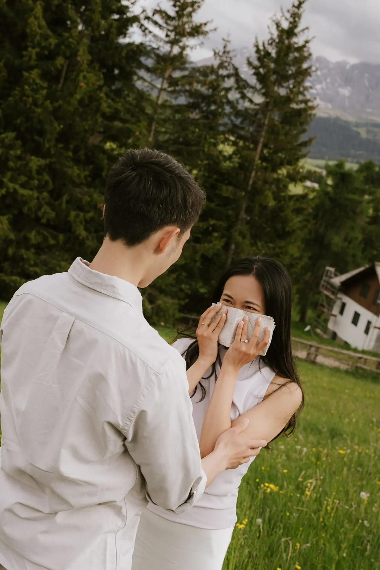 She wipes away happy tears in her partner's arms at the edge of the forest