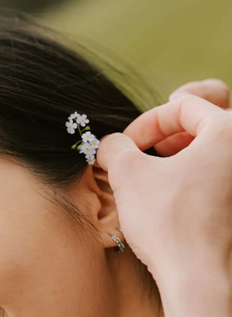 He tucks a forget-me-not behind her ear