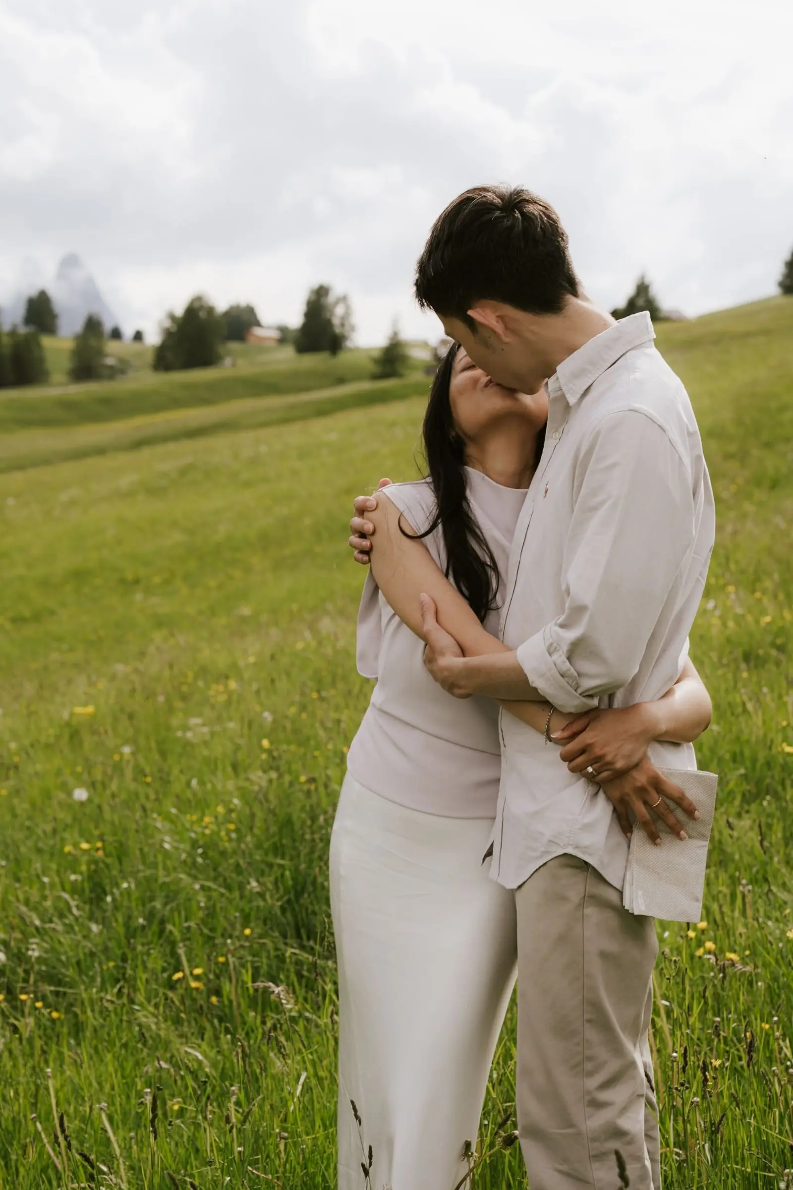 Couple kissing in a tight embrace in the meadow