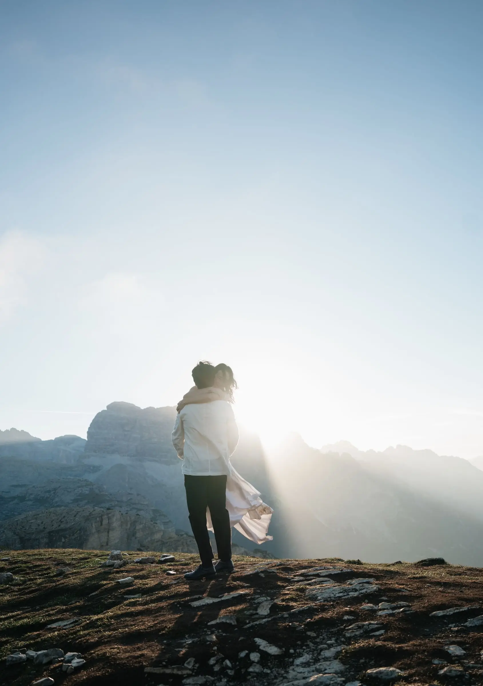 Groom lifts the bride into the sunrise light on the ridge