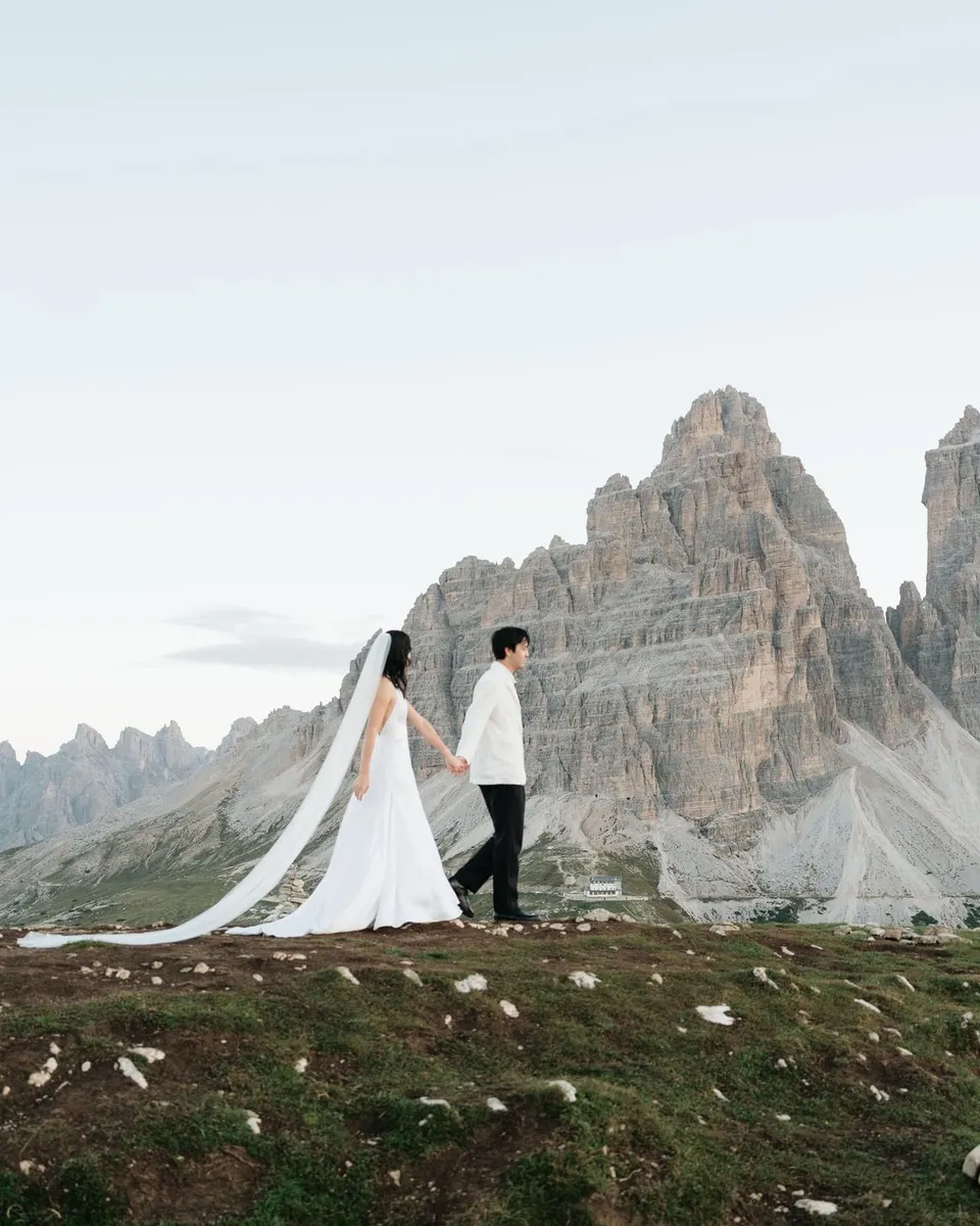 Couple walking with a long veil in front of the Tre Cime di Lavaredo