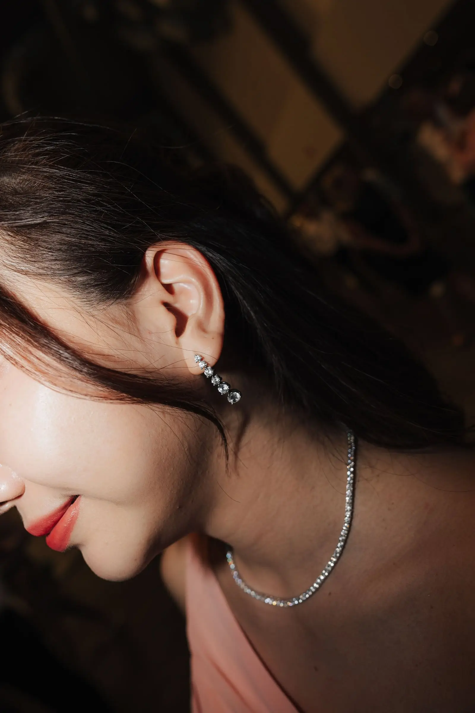 Close-up of a bridesmaid's earring and diamond necklace