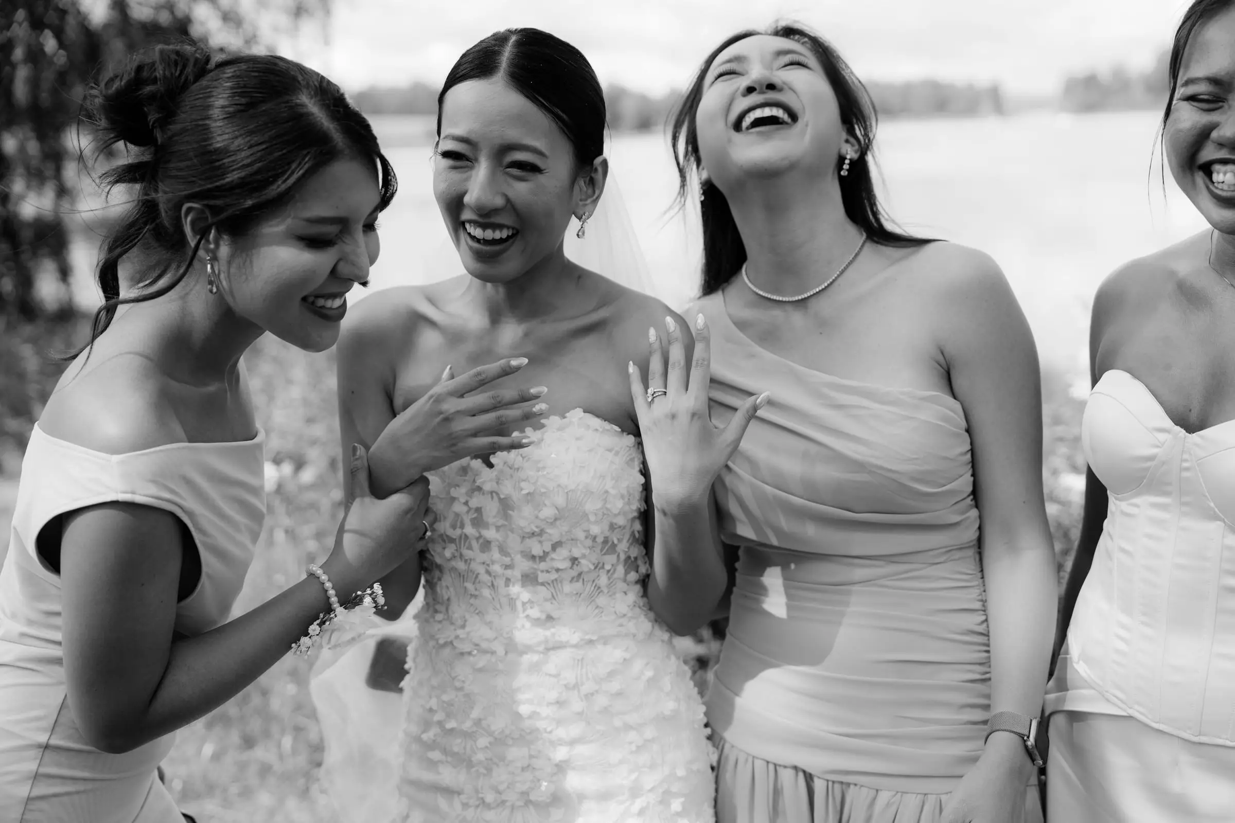 Black and white photo of the bride laughing with her bridesmaids
