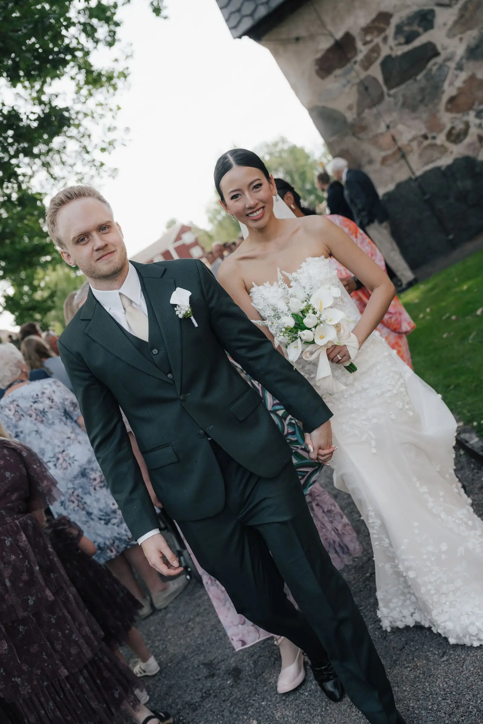 Newlyweds walking out of the church through their guests