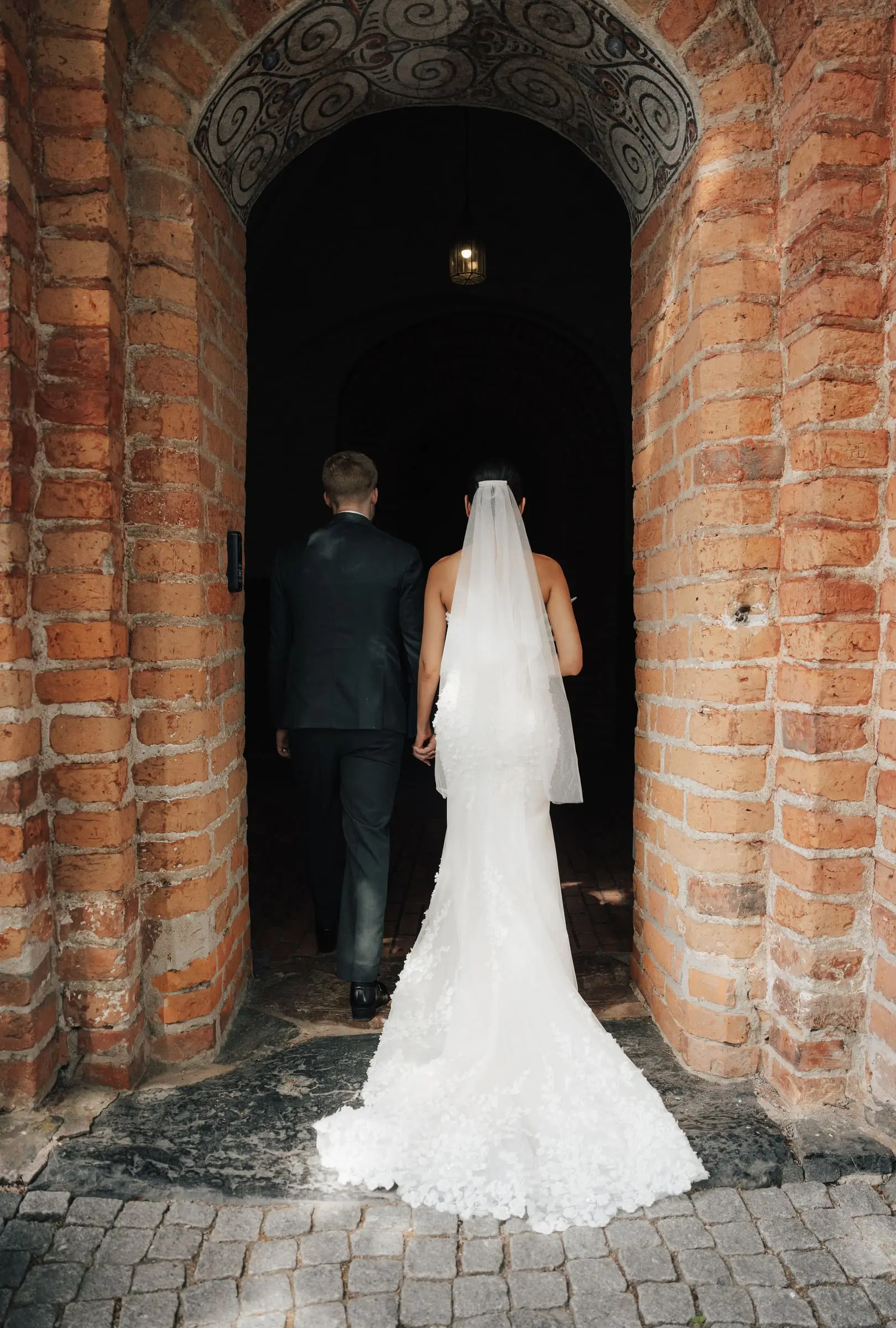 Bride and groom walking into the red brick church entrance