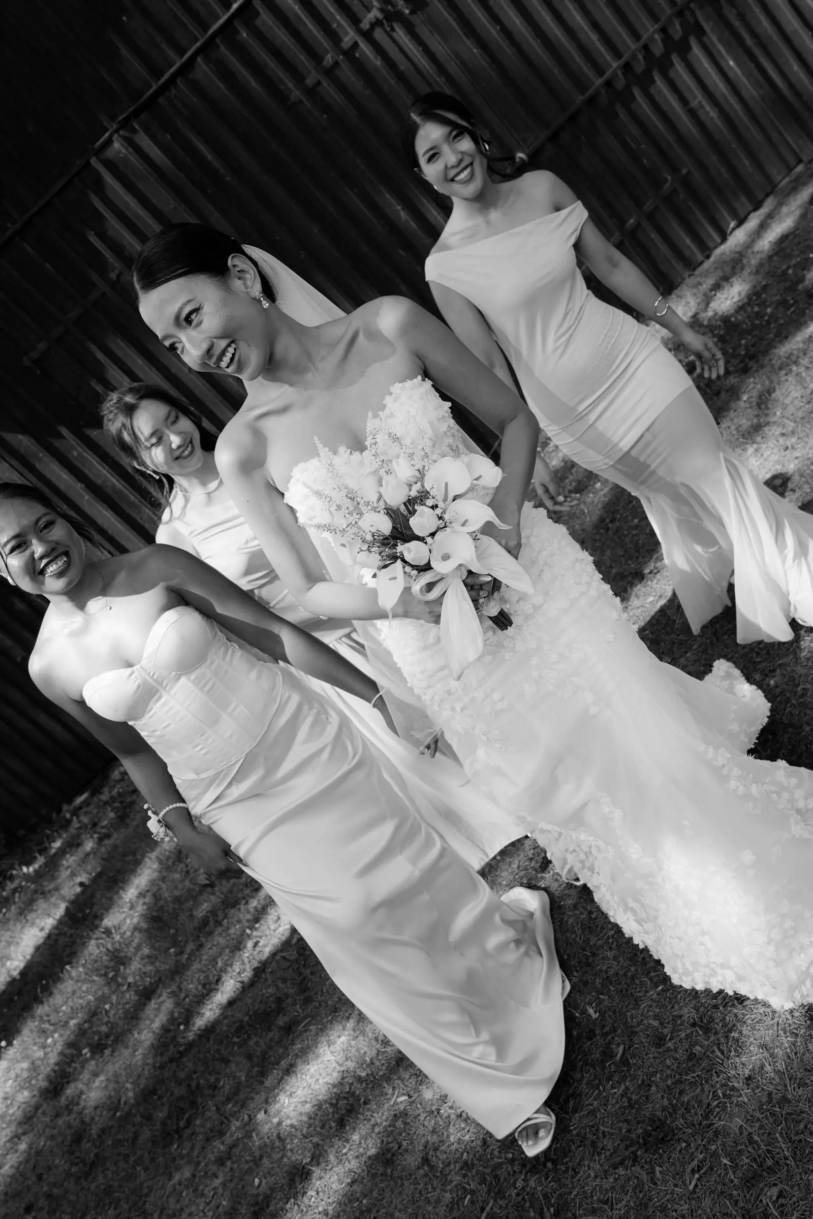 Black and white photo of the bride walking with her bridesmaids