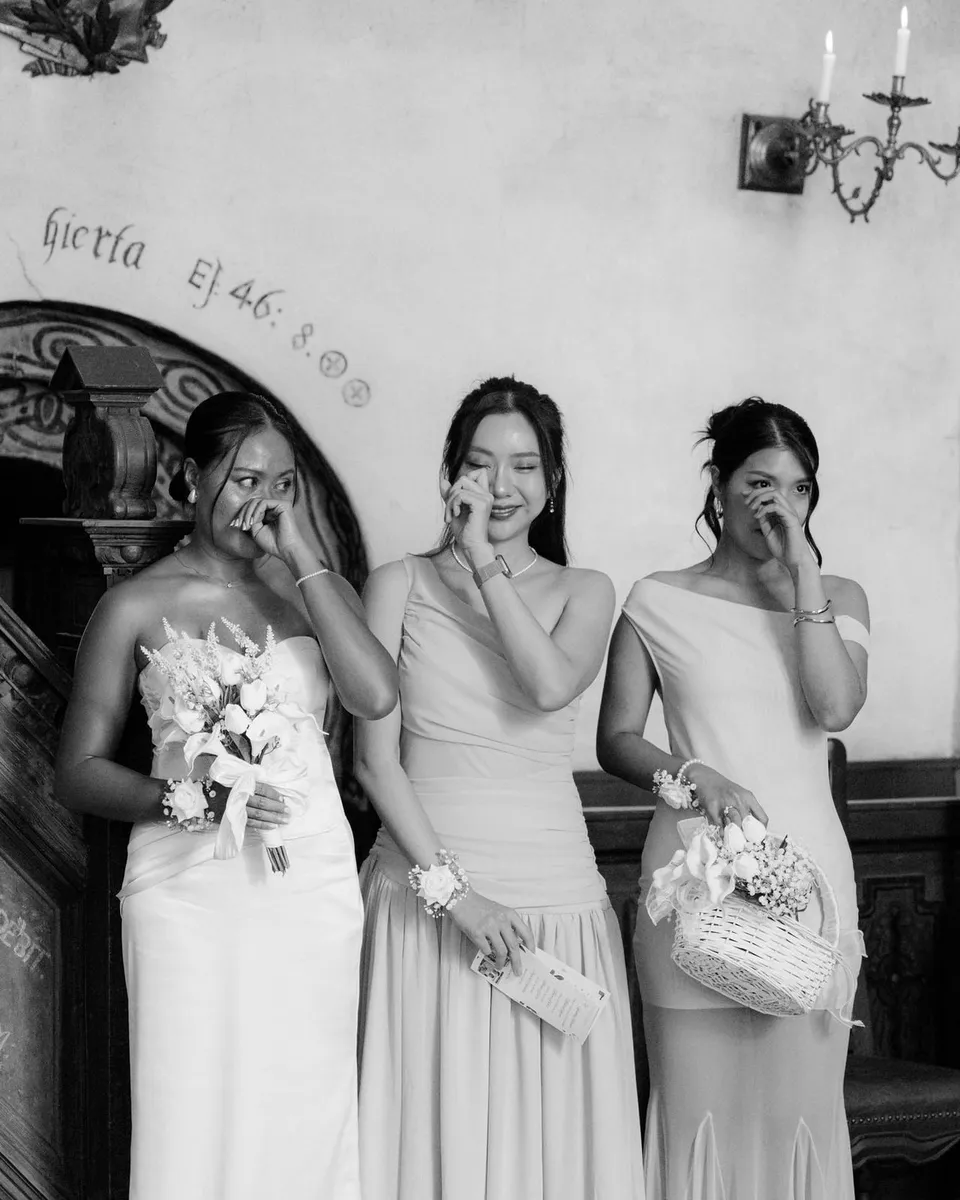 Black and white photo of bridesmaids crying by the church pulpit