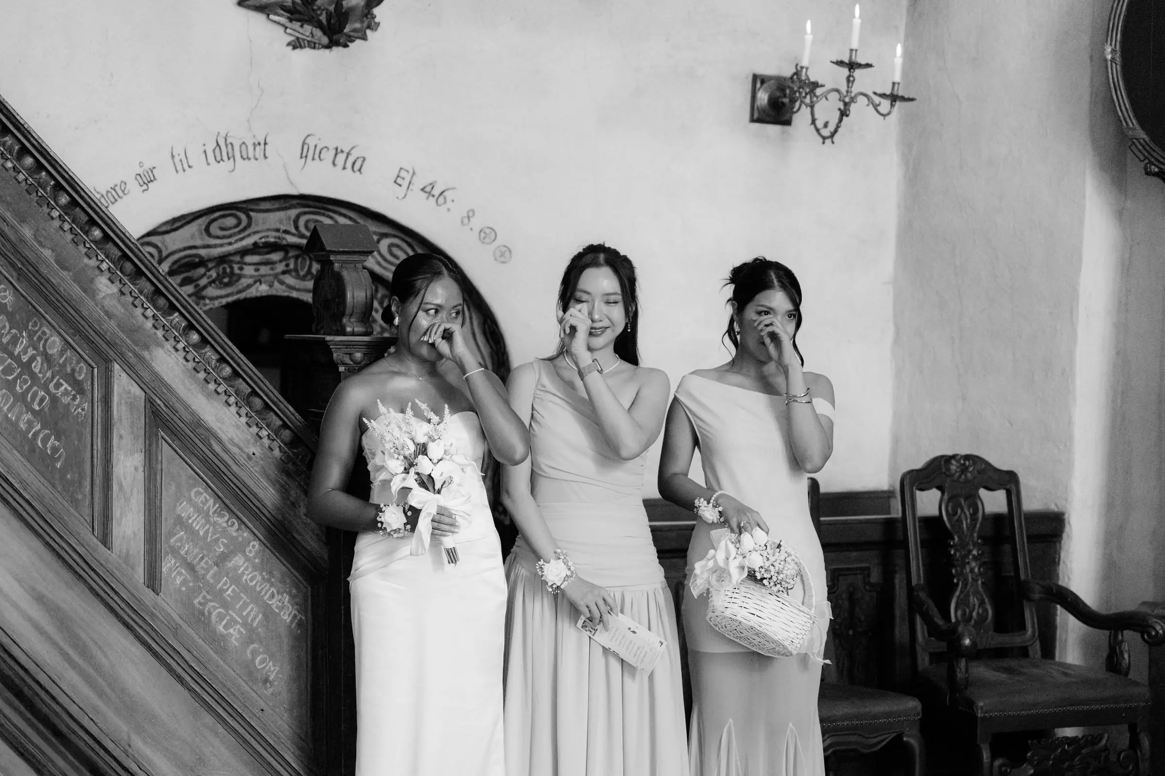 Black and white photo of bridesmaids crying by the church pulpit