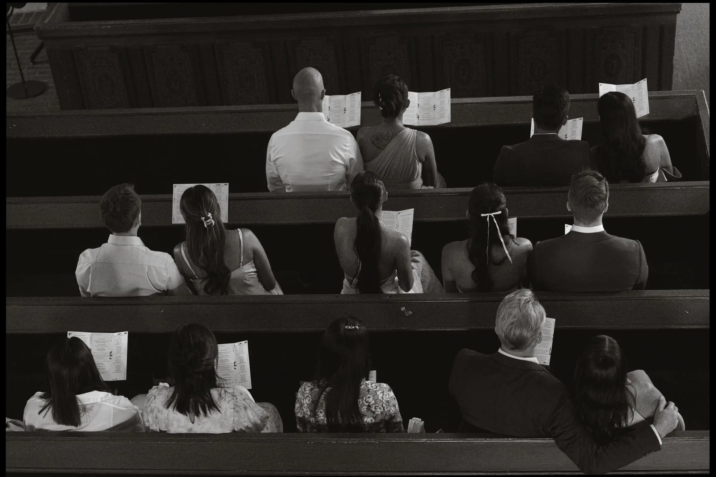 Black and white photo of guests in the church pews from above