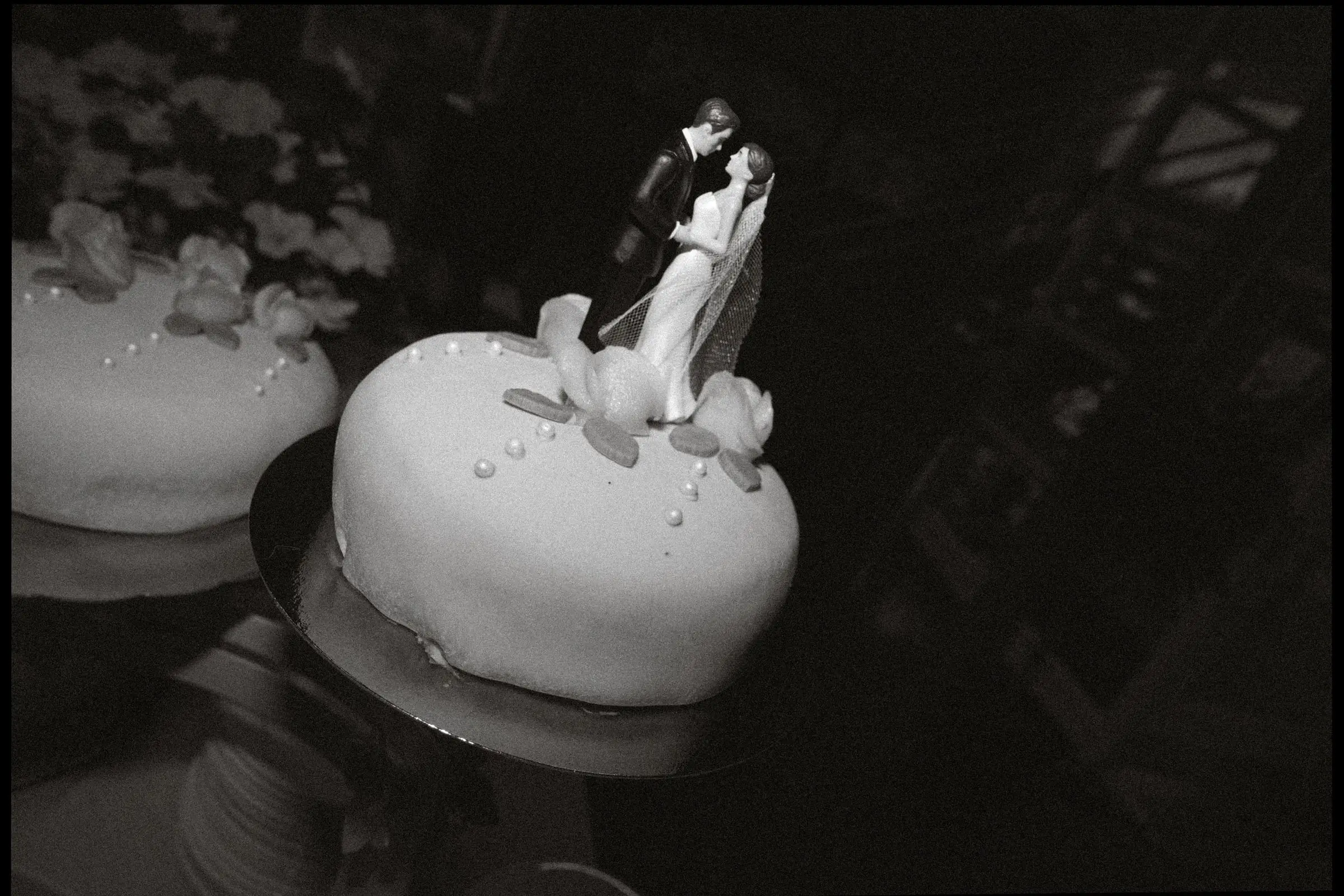 Black and white photo of the wedding cake with its topper