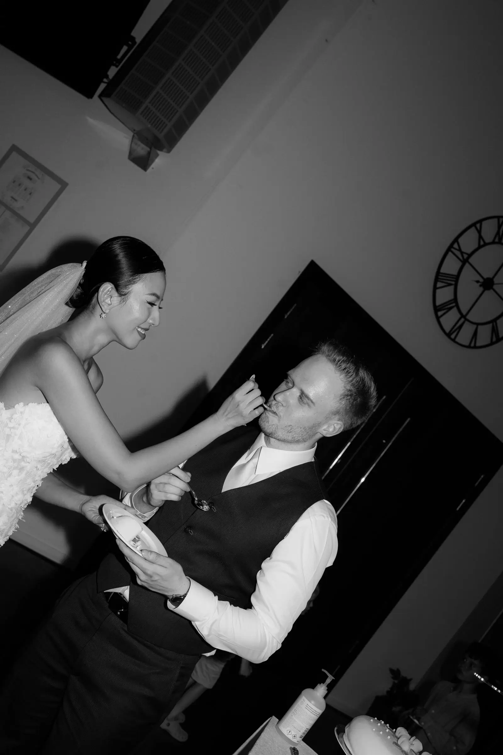 Black and white photo of the bride feeding the groom cake