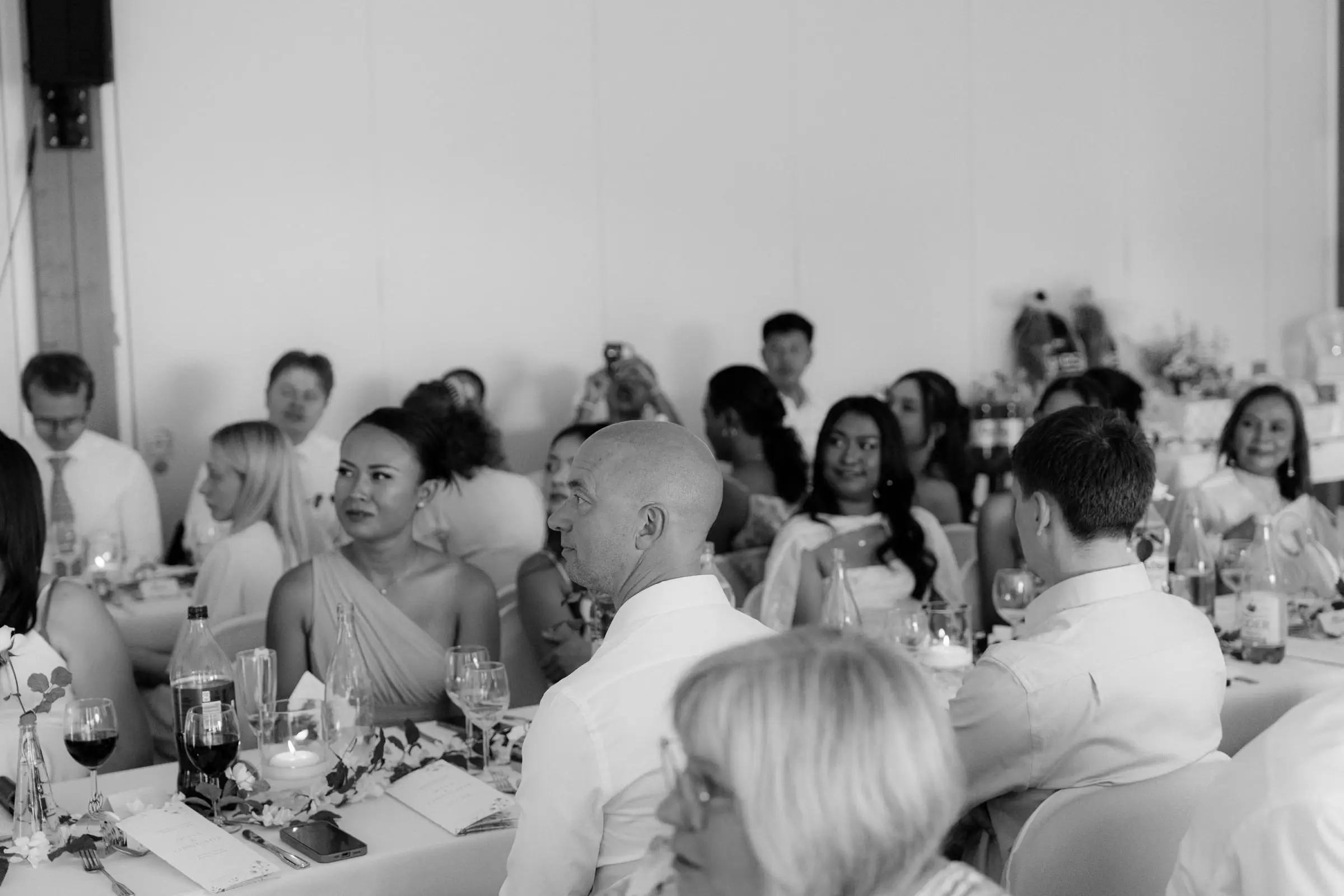 Black and white photo of guests at the reception listening to speeches