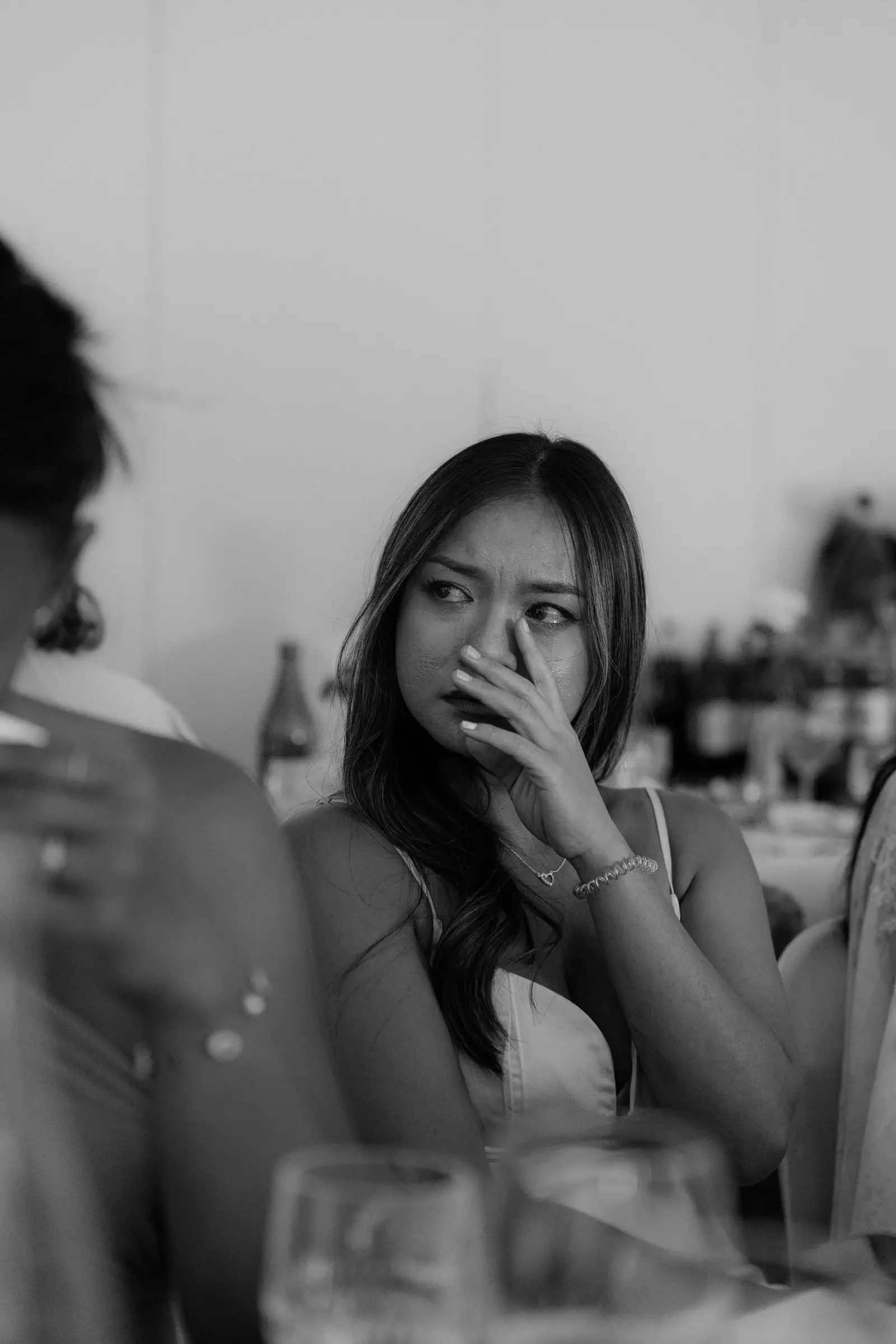 Black and white photo of a guest wiping a tear during the speeches