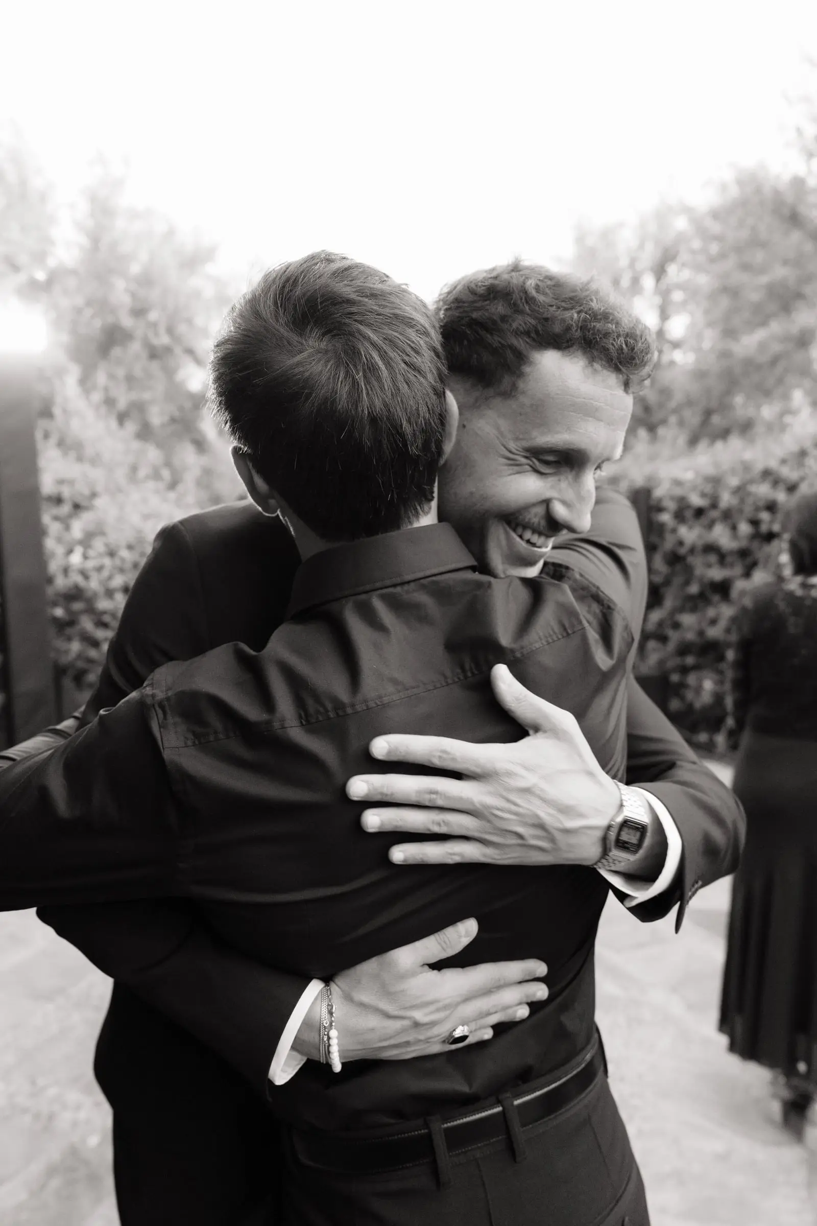 Black and white photo of guests hugging at the welcome party