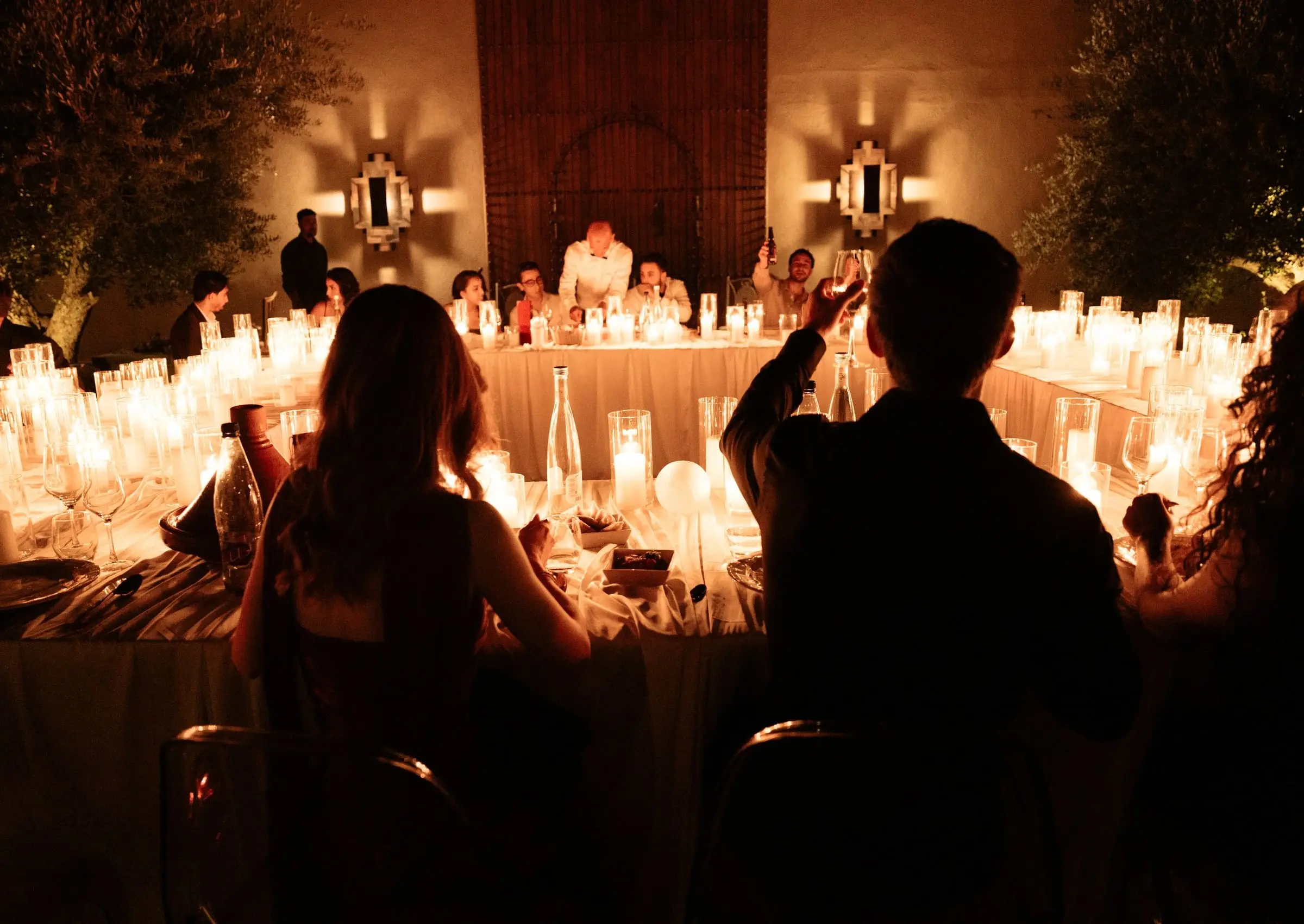 Candlelit courtyard dinner with guests raising a toast