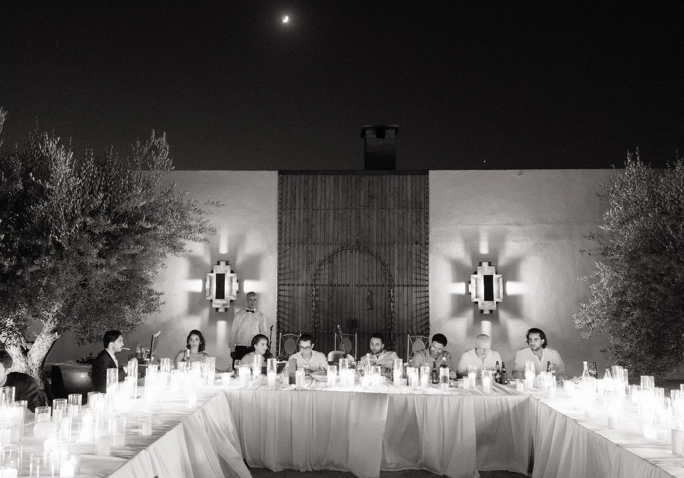 Black and white photo of the candlelit courtyard table under the moon
