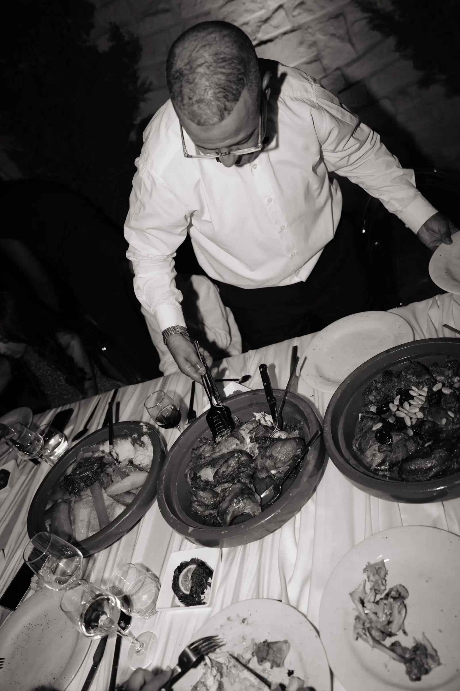 Black and white photo of a guest serving from Moroccan dishes