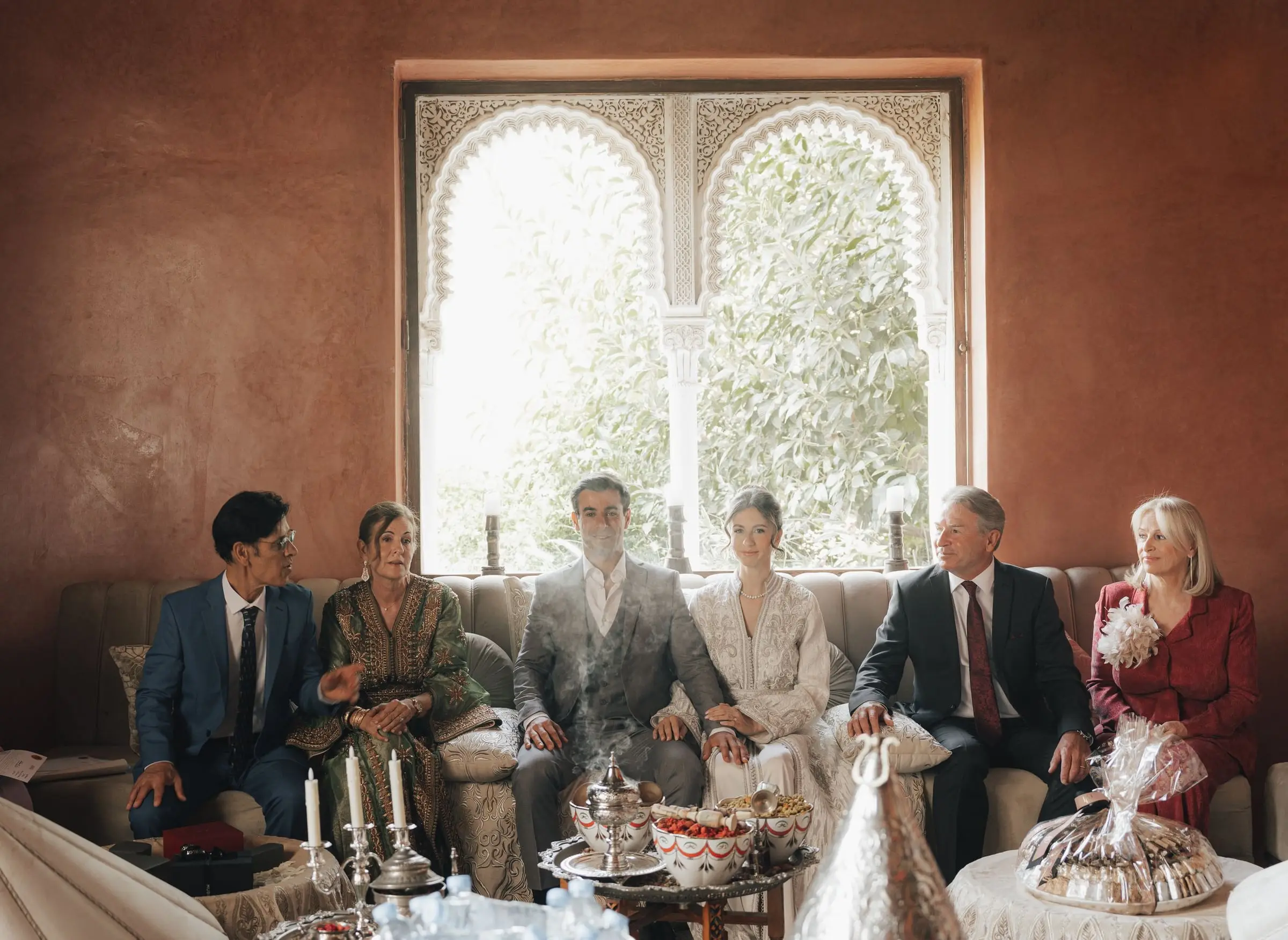Families gathered in a salon with a Moorish arched window for the civil wedding