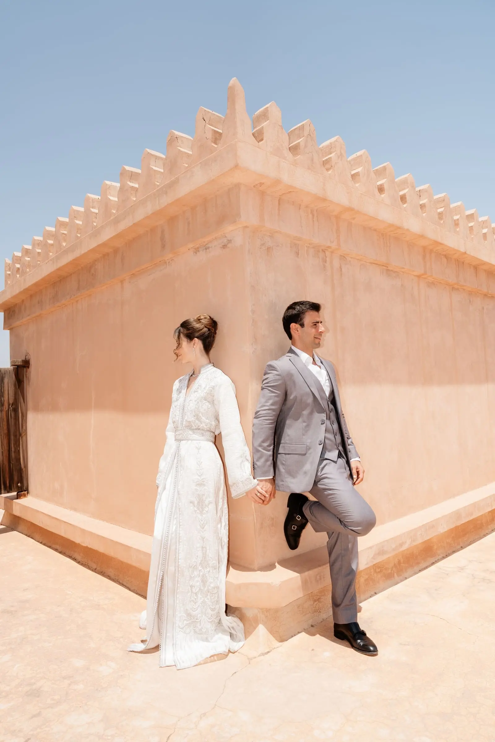 Couple by the crenellated walls of Ksar Char Bagh