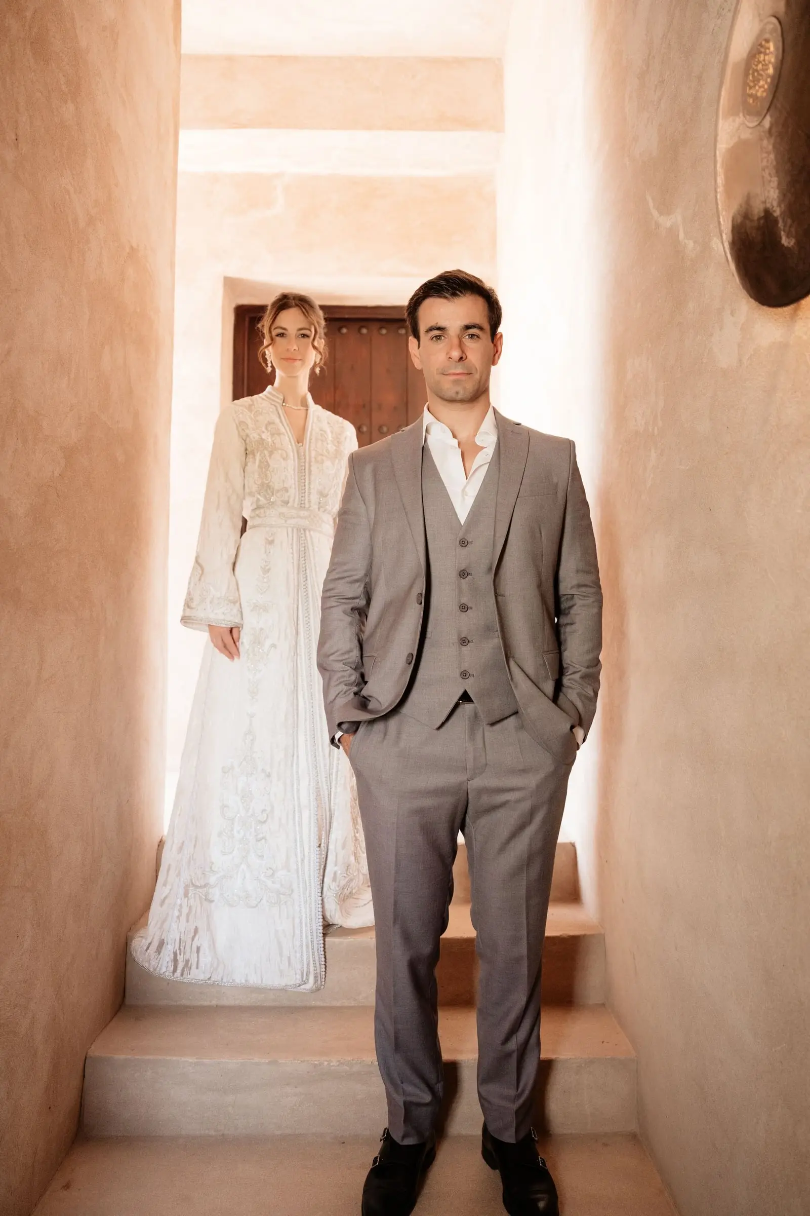 Couple standing in a narrow earth-coloured passage