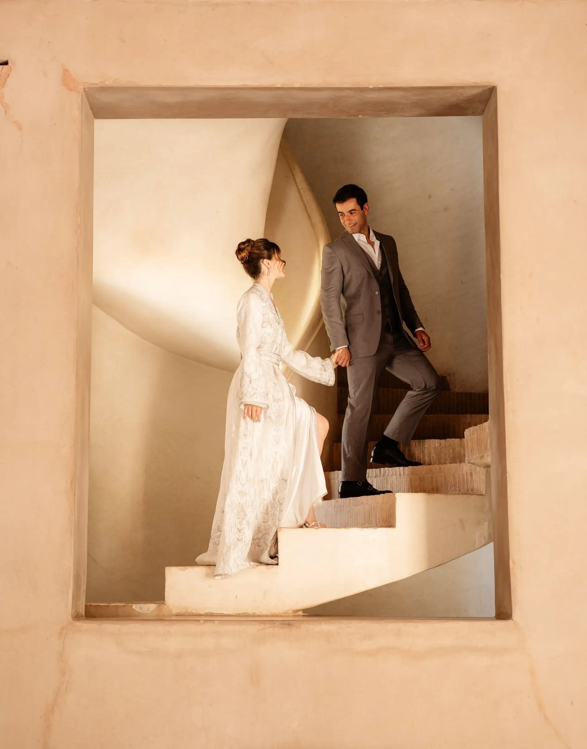 Couple on a spiral staircase seen through a window in the palace walls