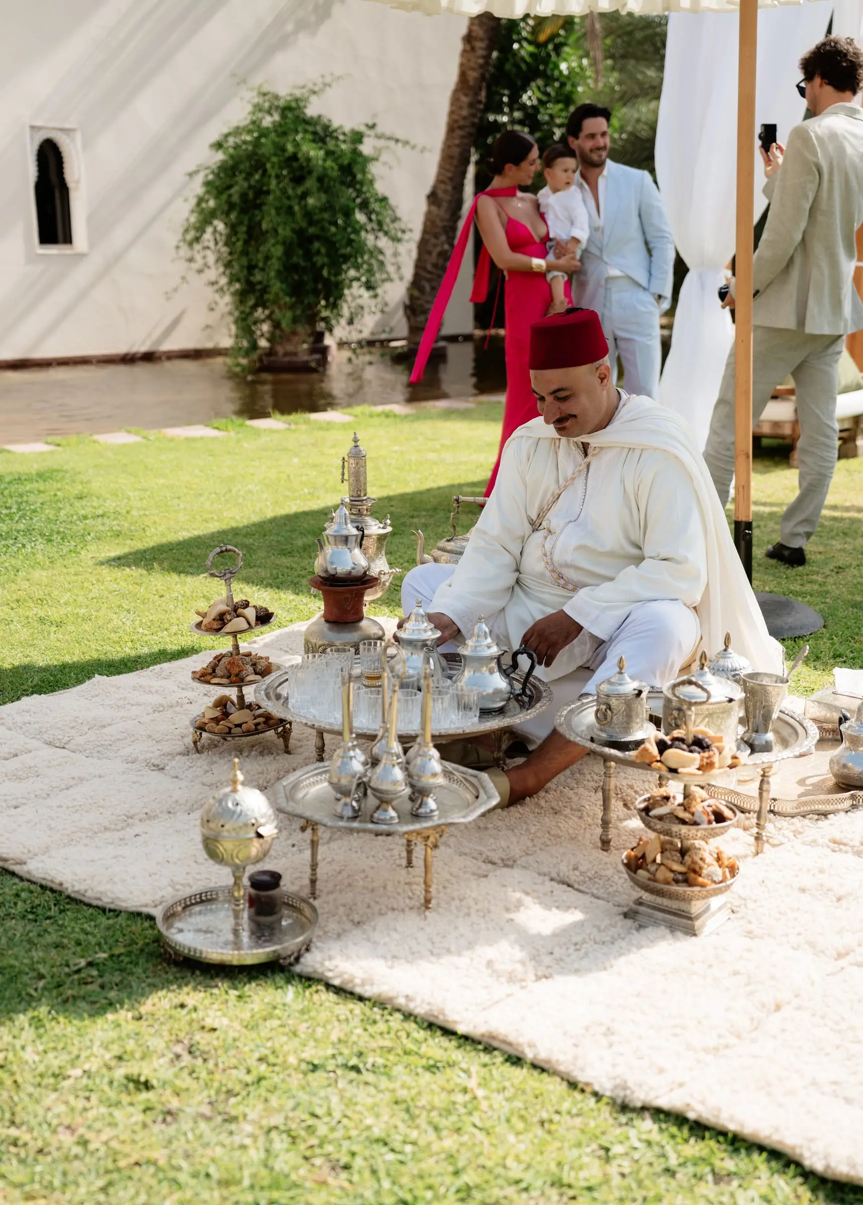 Tea master in a fez preparing Moroccan mint tea on the lawn