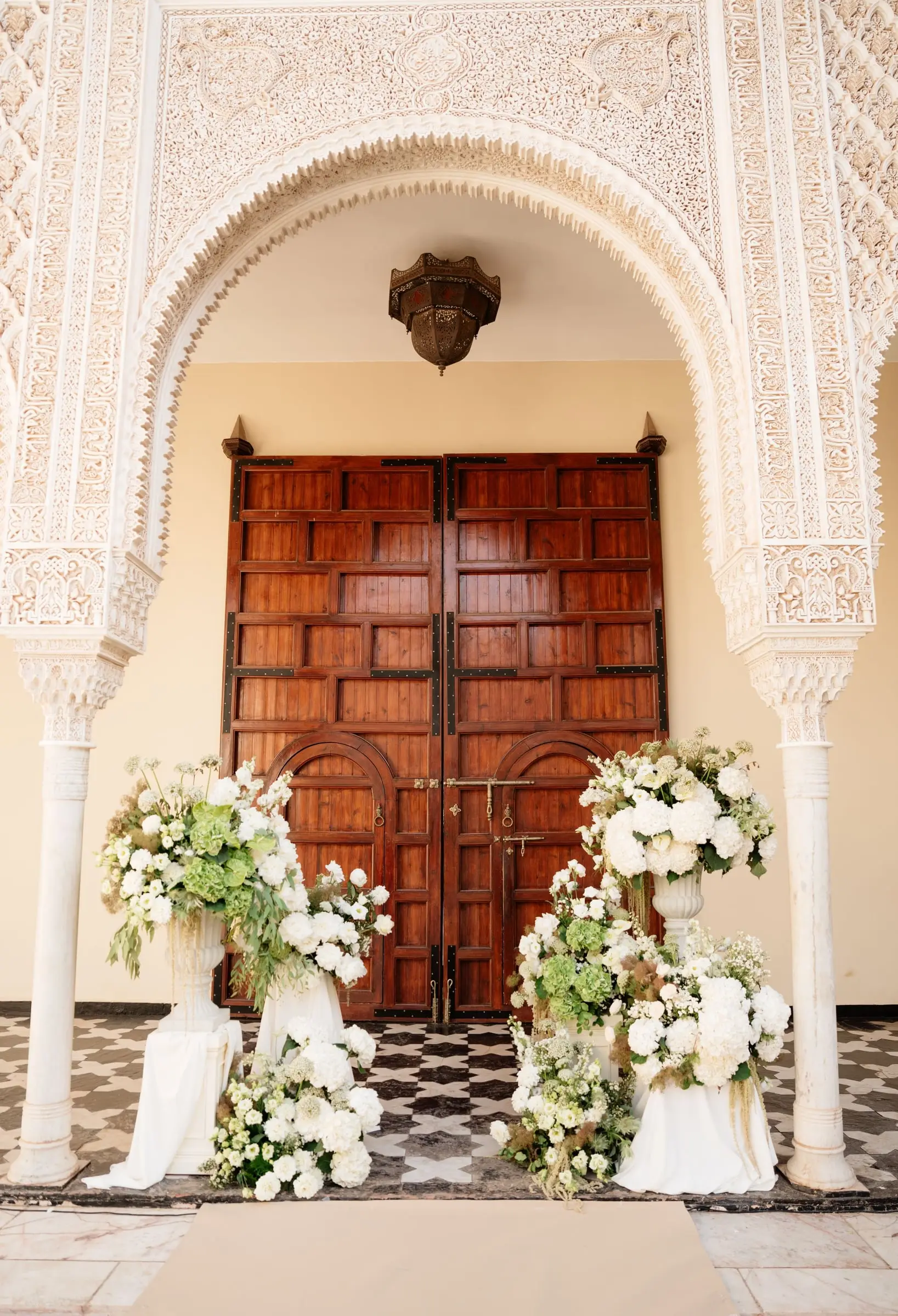 Carved Moorish archway and wooden doors decorated with white flowers