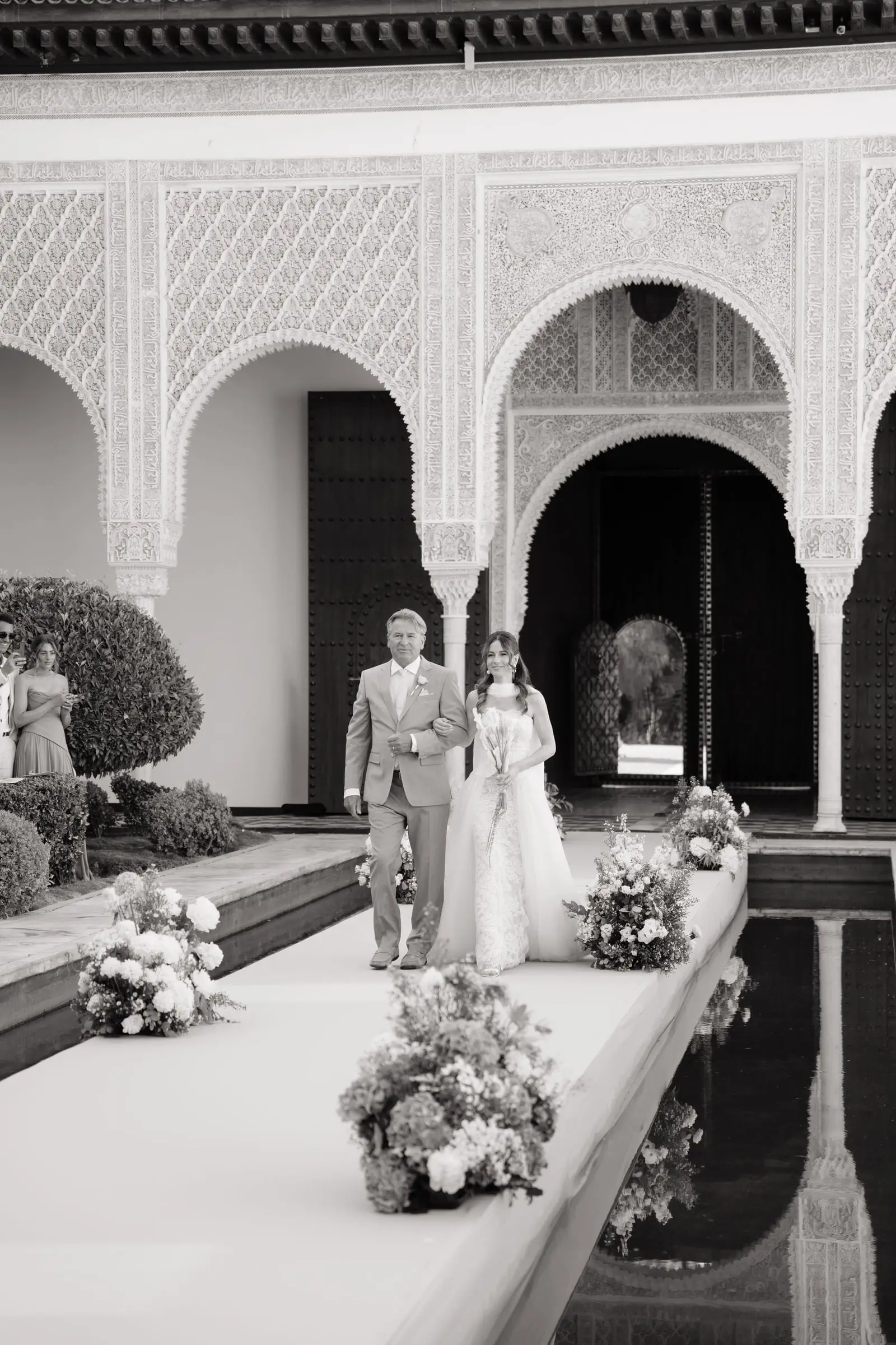 Black and white photo of the bride and her father walking down the aisle