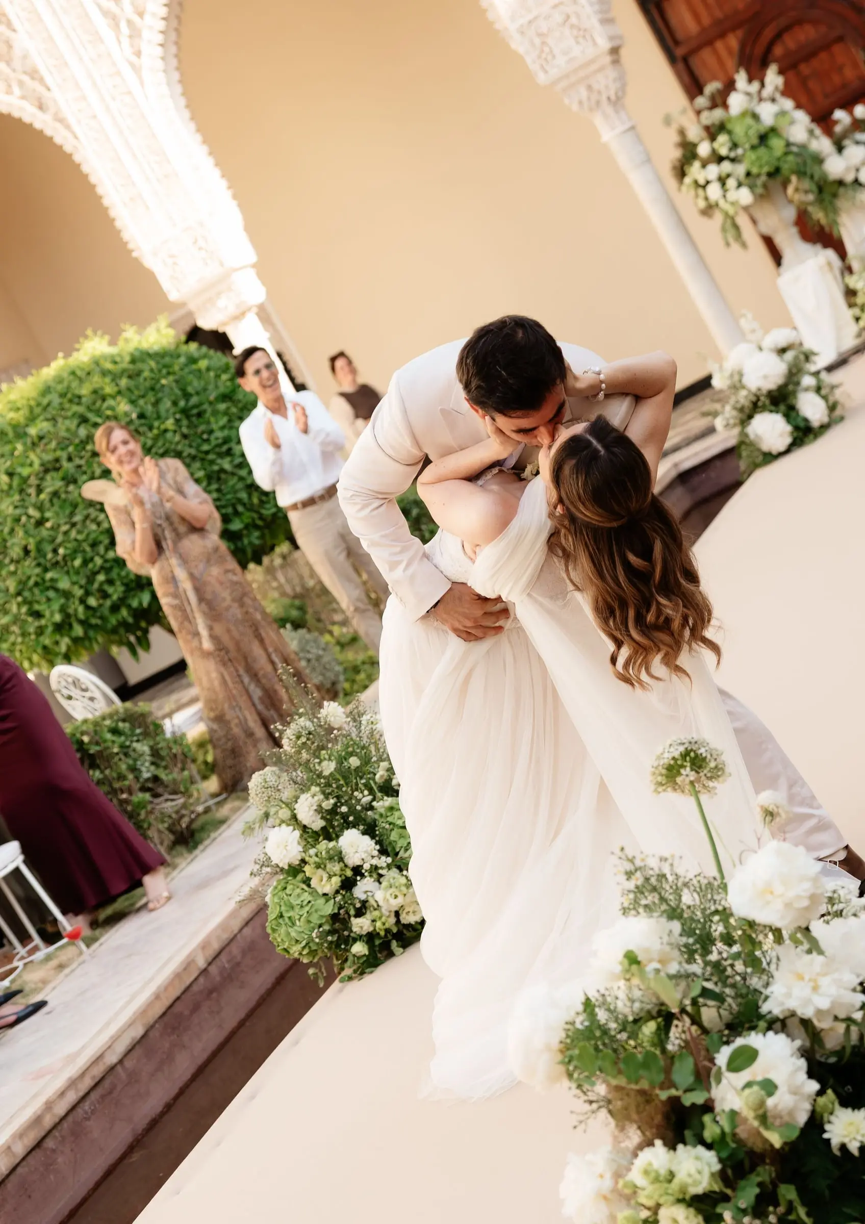 Groom dips and kisses the bride at the end of the aisle