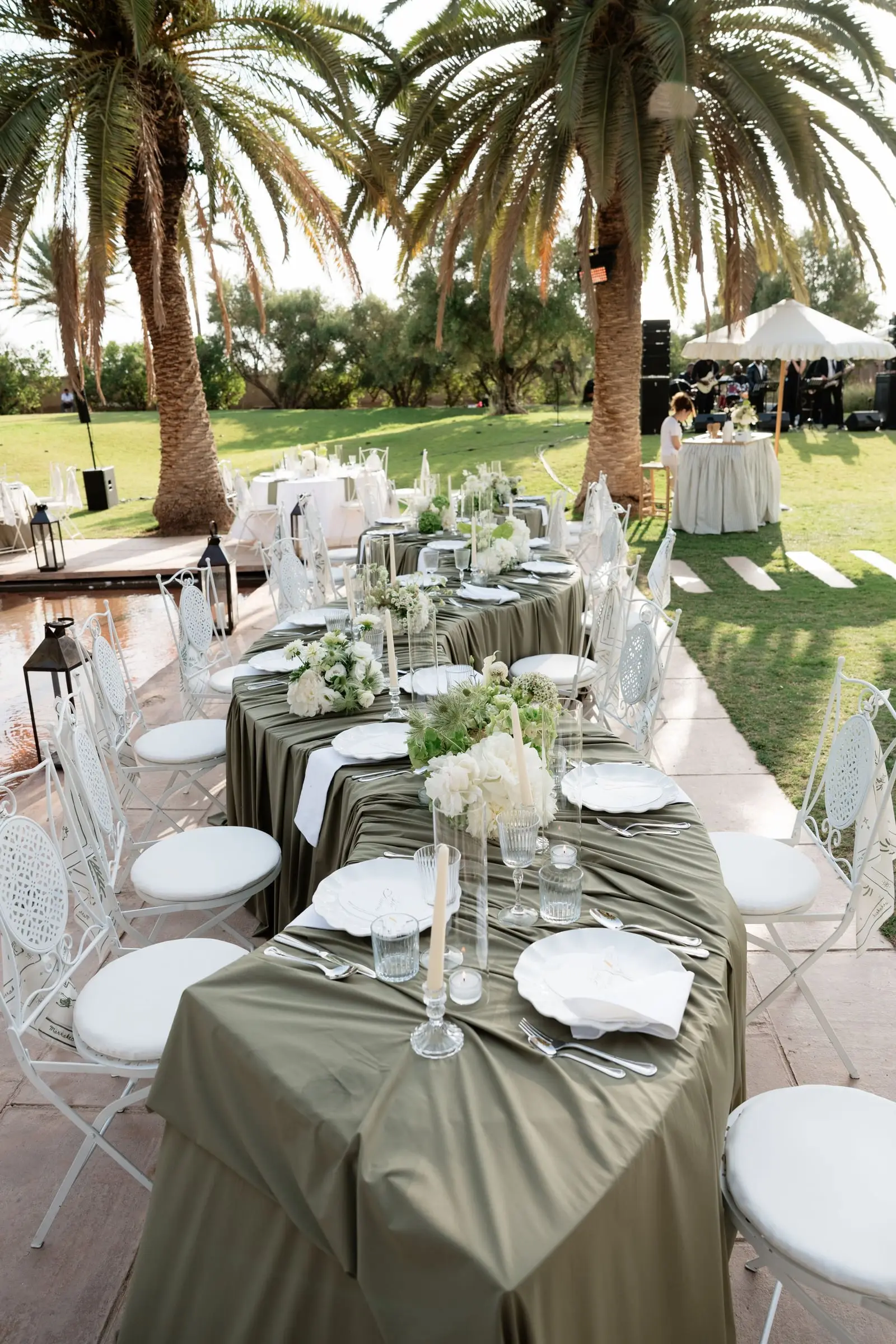 Dinner tables with olive-green linen by the pool