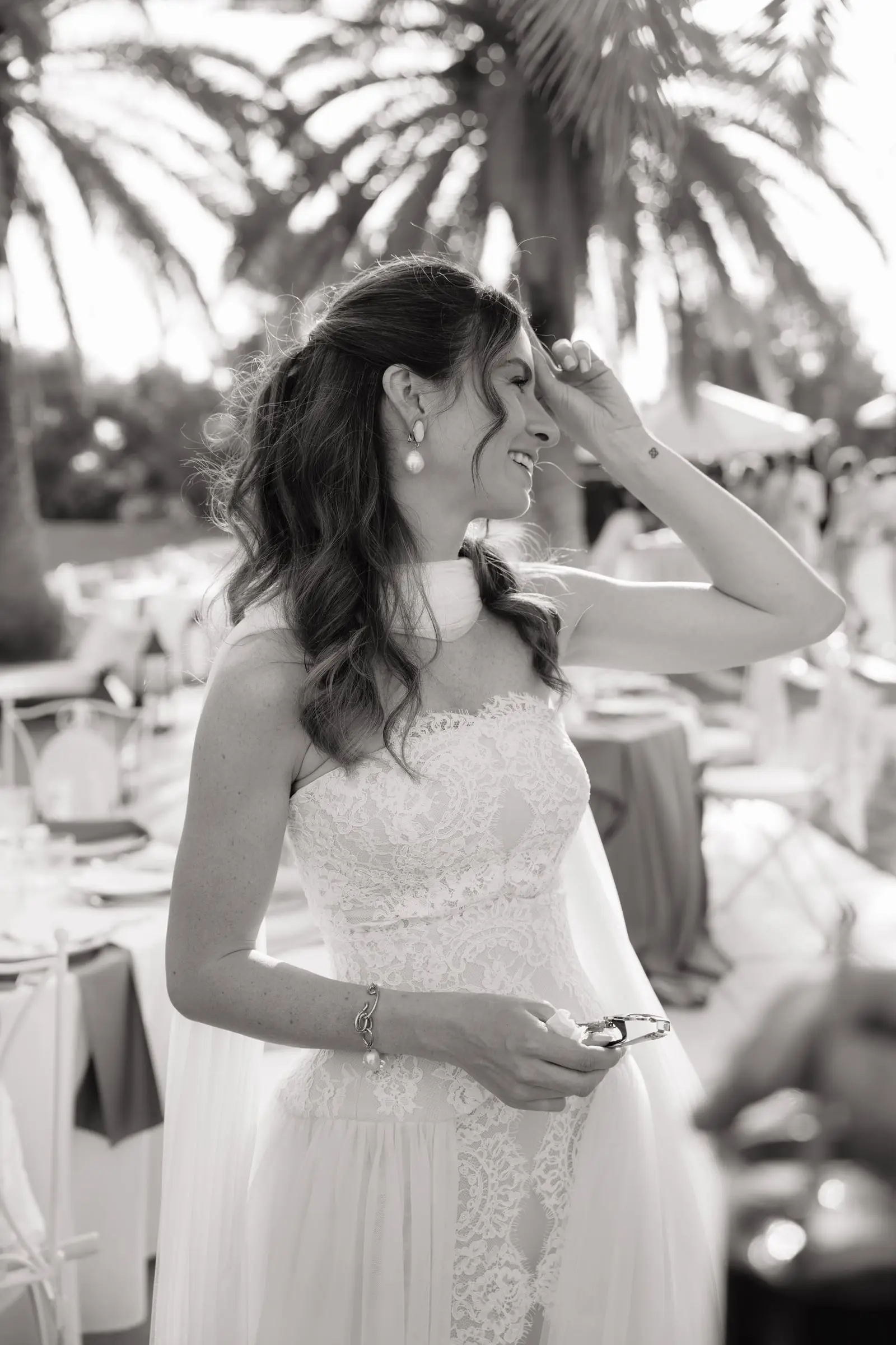 Black and white photo of the bride laughing with guests