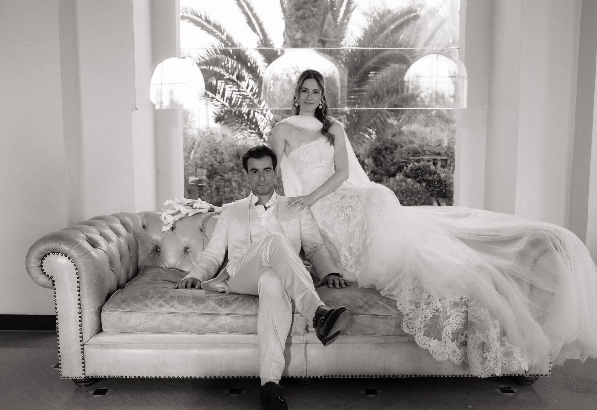 Black and white photo of the couple on a Chesterfield sofa