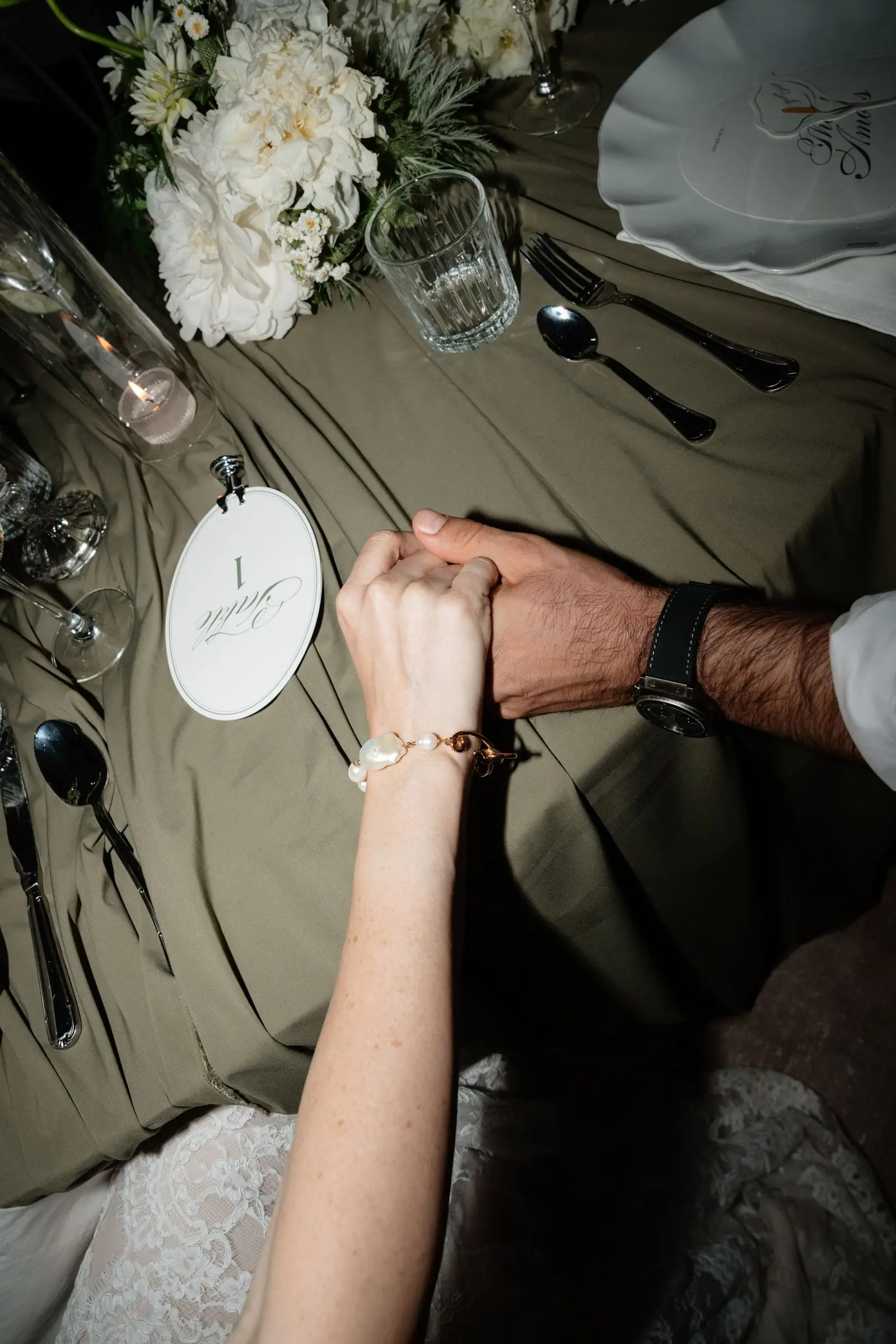 Couple holding hands across the dinner table
