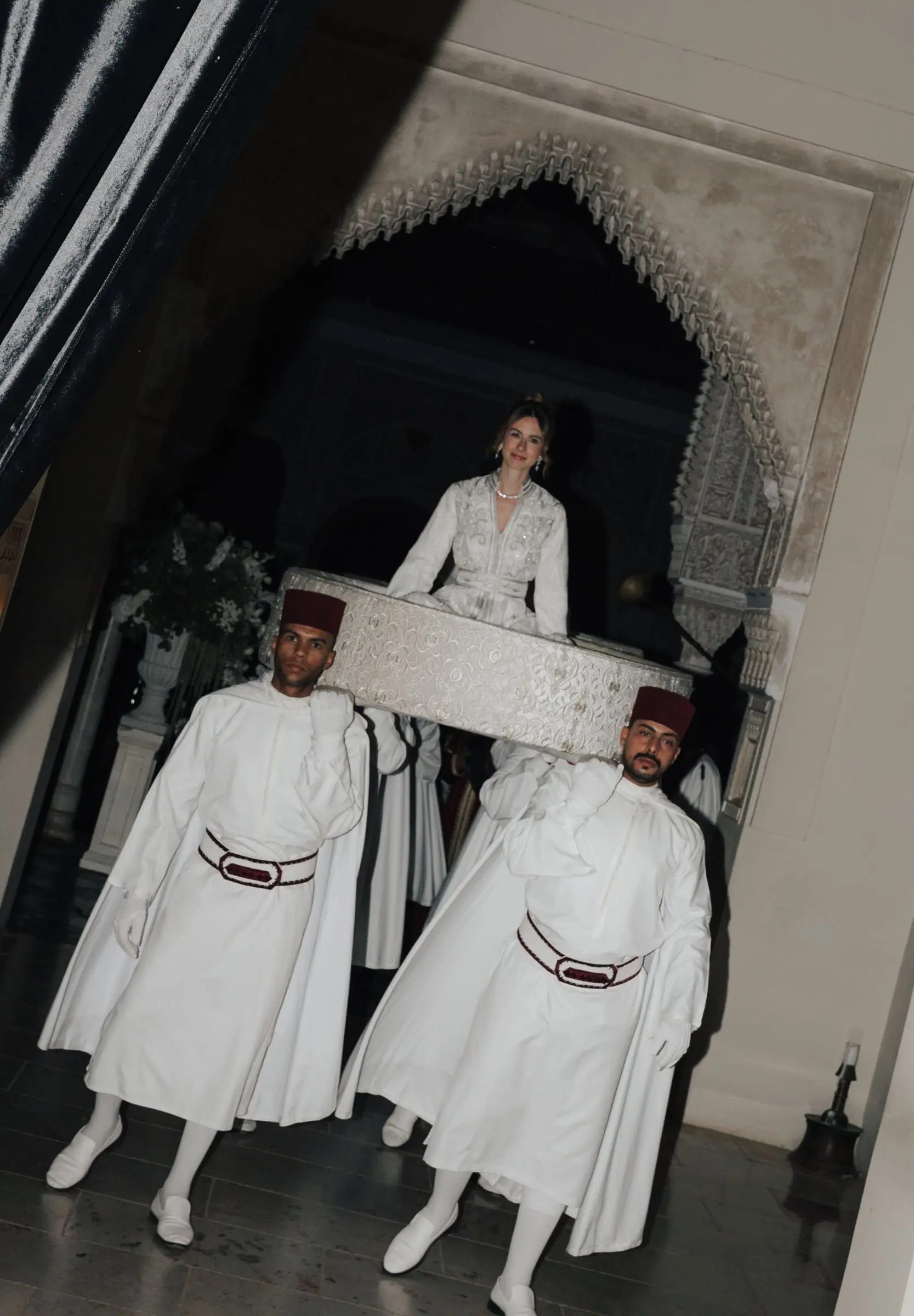 Bride in a Moroccan kaftan carried on the Amaria by men in traditional dress