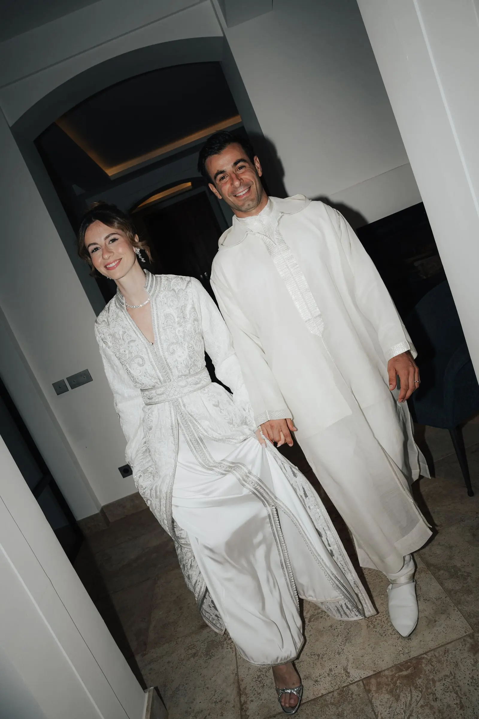 Couple in white Moroccan outfits entering the party