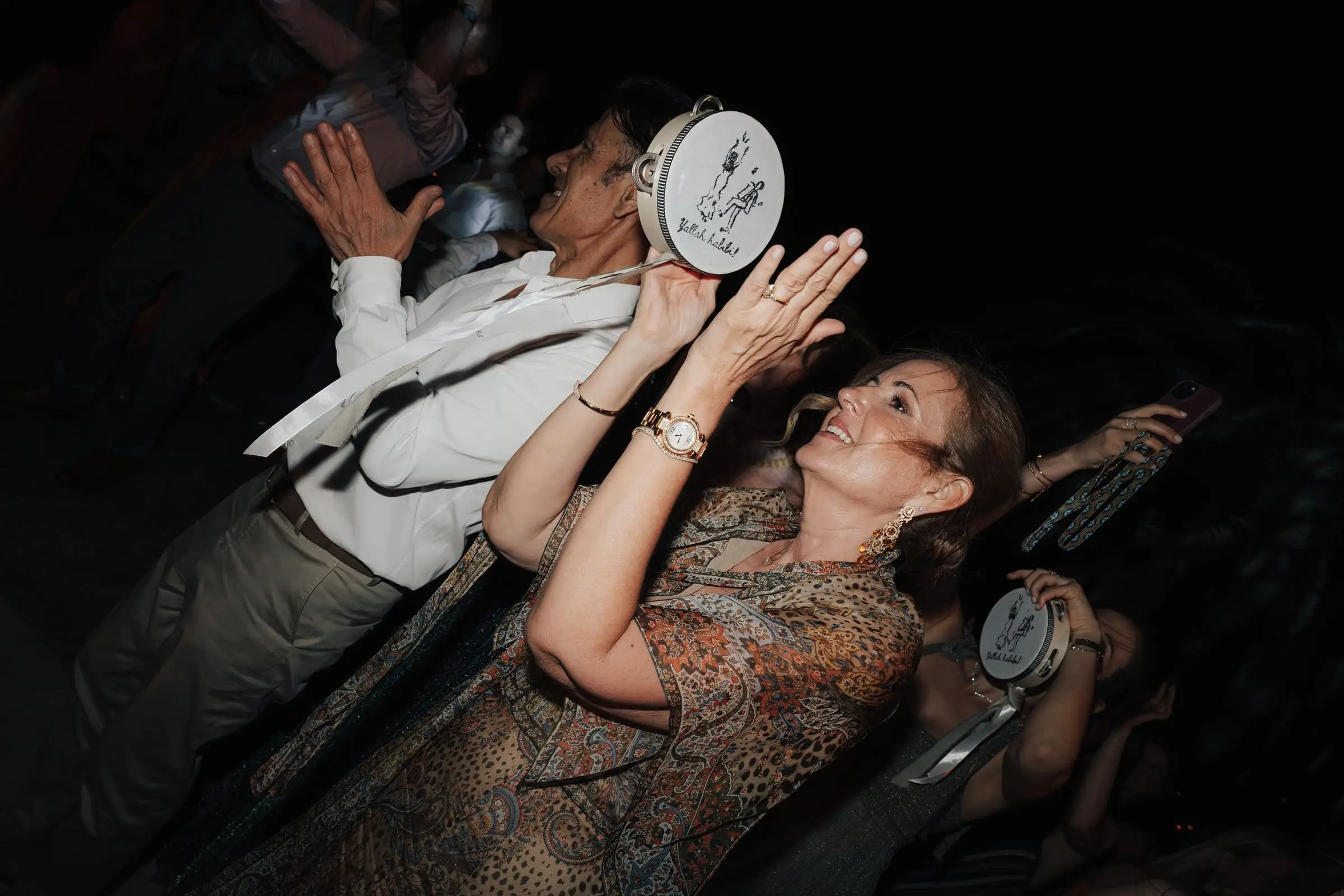 Guests dancing and playing tambourines at night