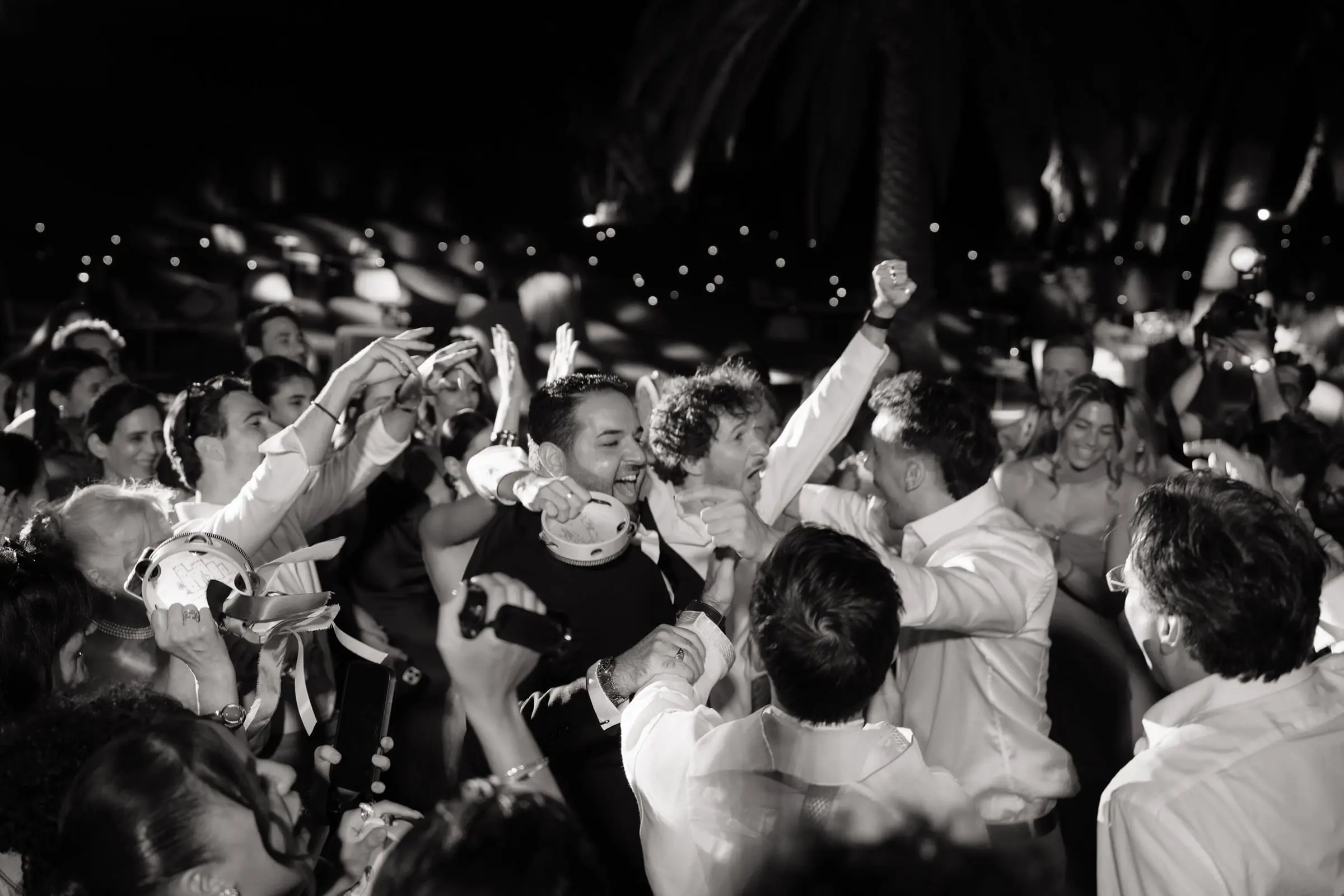 Black and white photo of guests celebrating on the dance floor