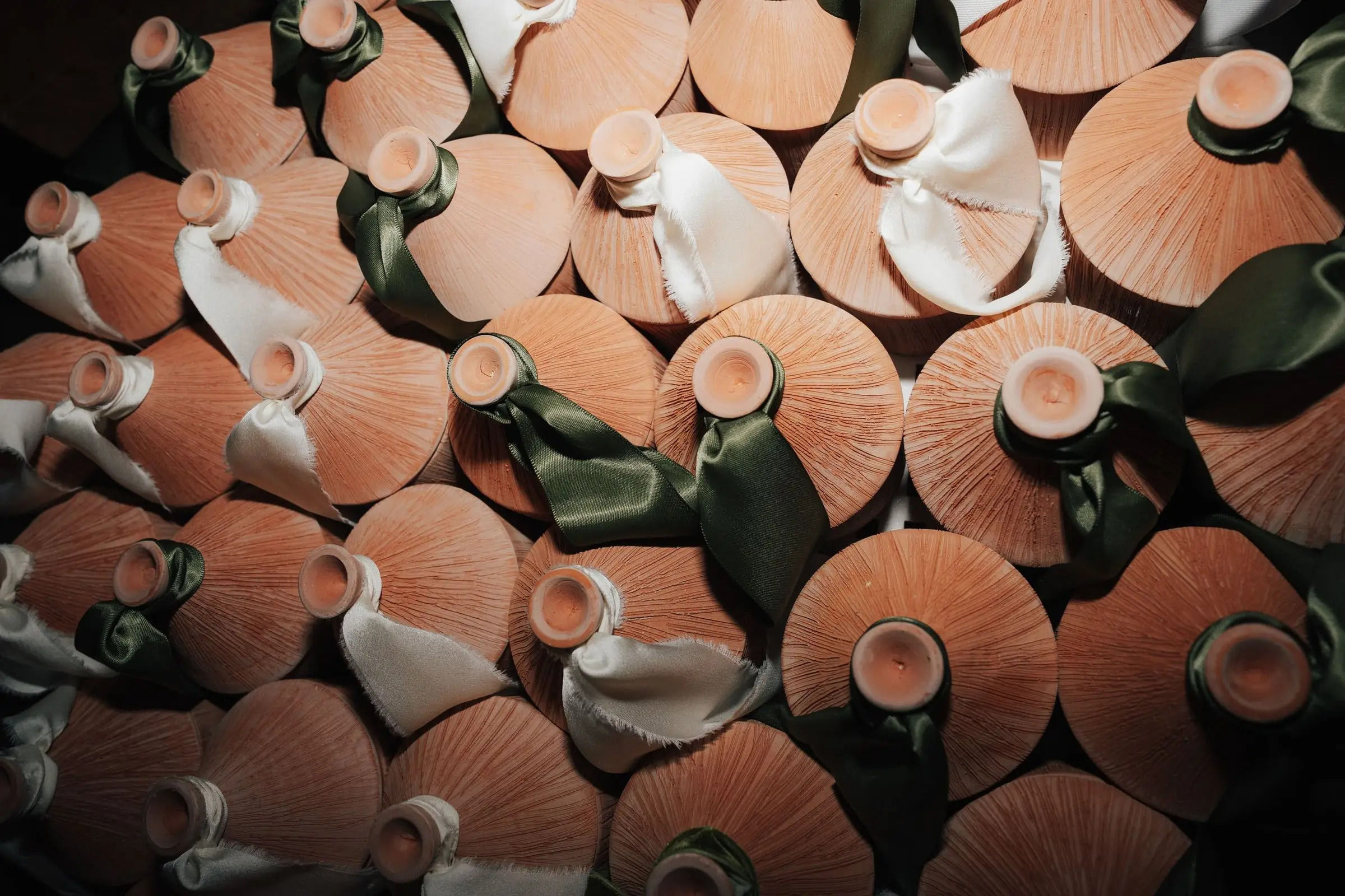 Terracotta favours tied with green ribbons, on film